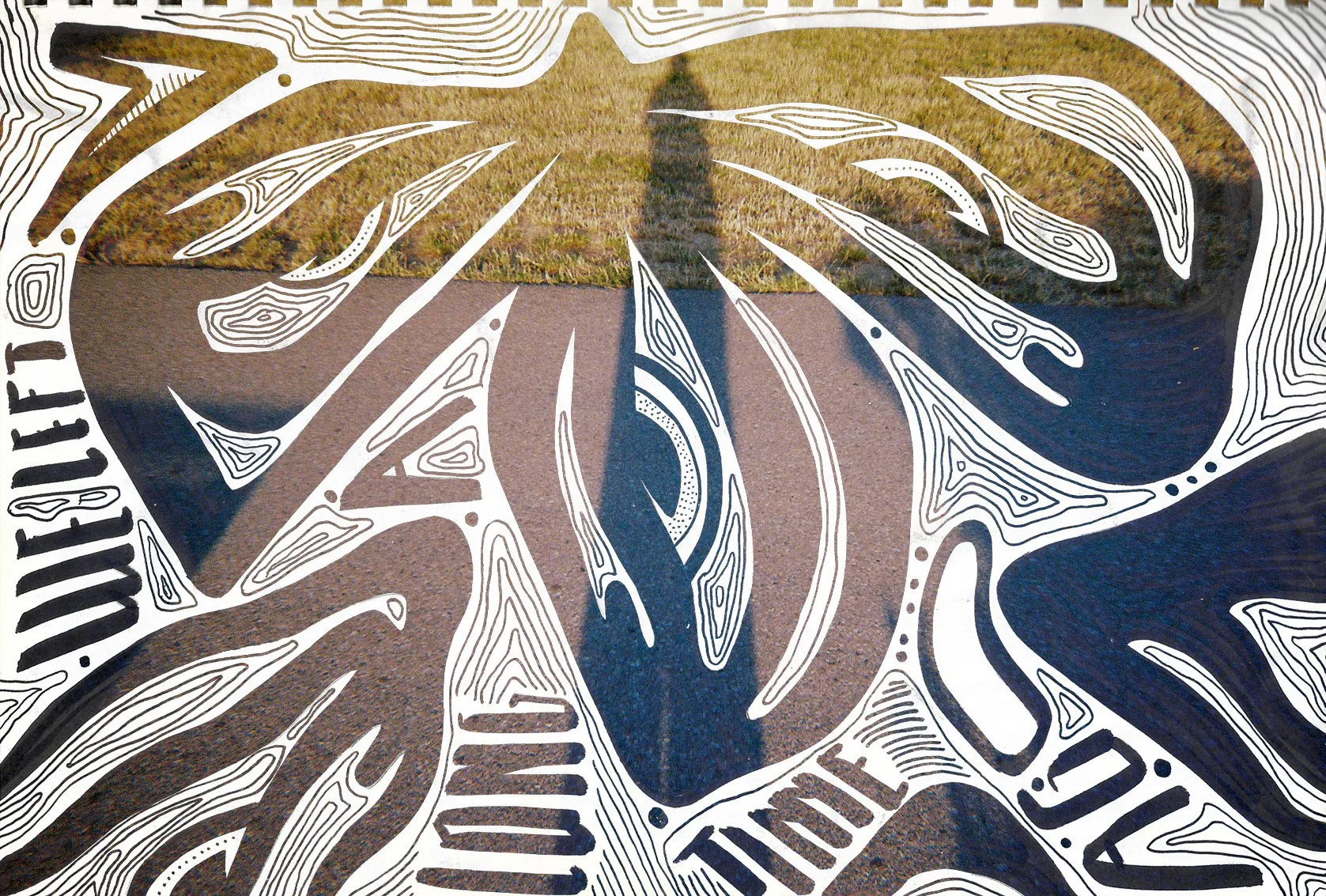 A sidewalk with a large circular artwork painted on it, surrounded by white line drawings of abstract shapes and text. The artwork includes a central arrow shape and the words "WELL FIT" and "TULSA" are visible.