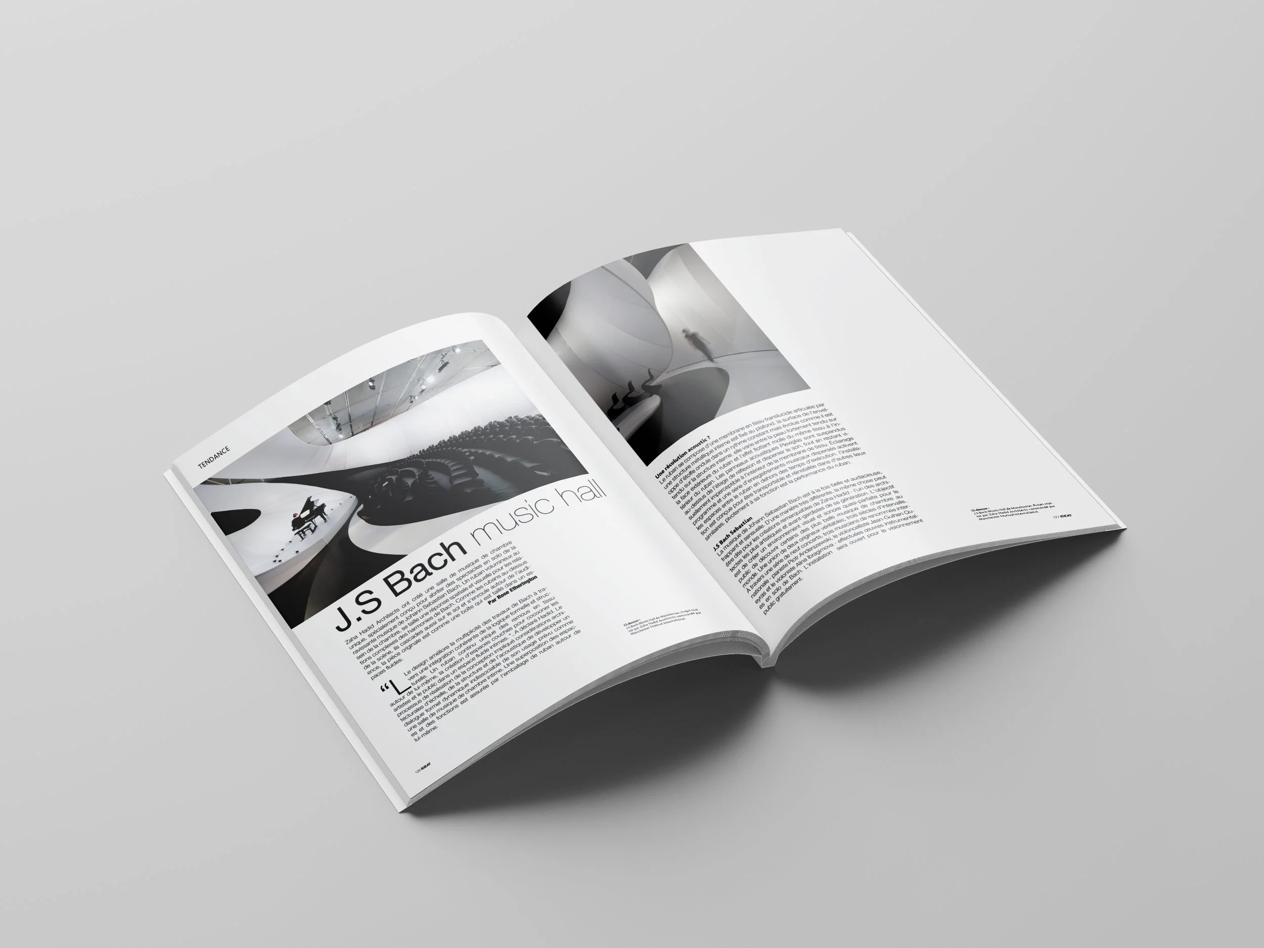 Open magazine with black and white images and text about J.S. Bach's music hall, placed on a gray surface.