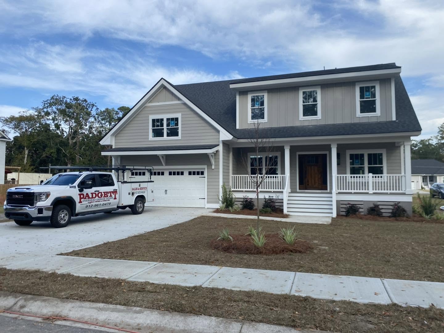 Front landscape of House with Padgett Overhead Garage doors truck sitting in the drive way.