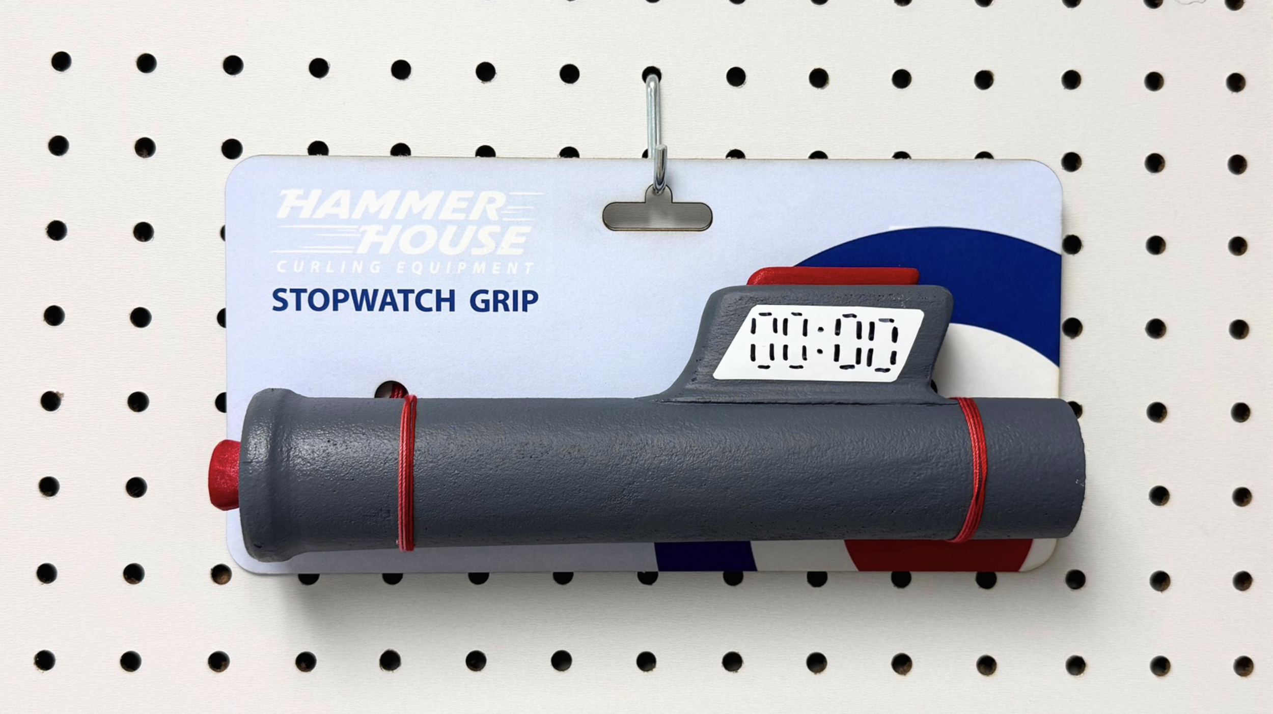 A black rolling pin with red straps hanging on a display hook, and a digital timer showing 00:00, attached to a peghook on a pegboard.