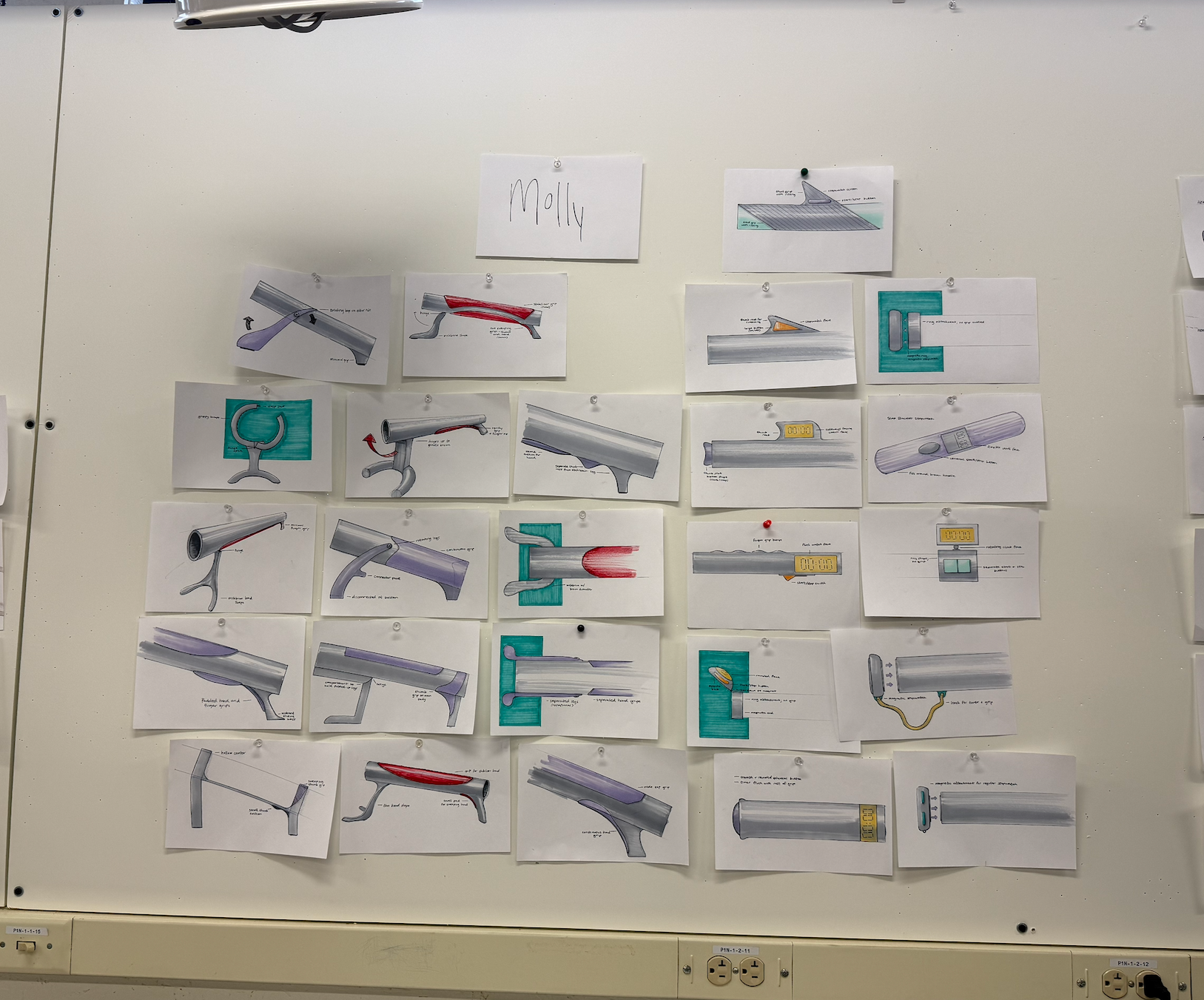 A wall covered with numerous sketches and diagrams of mechanical parts, some highlighted in red, gray, or purple, and a cardboard sign labeled 'Molly' at the top center.