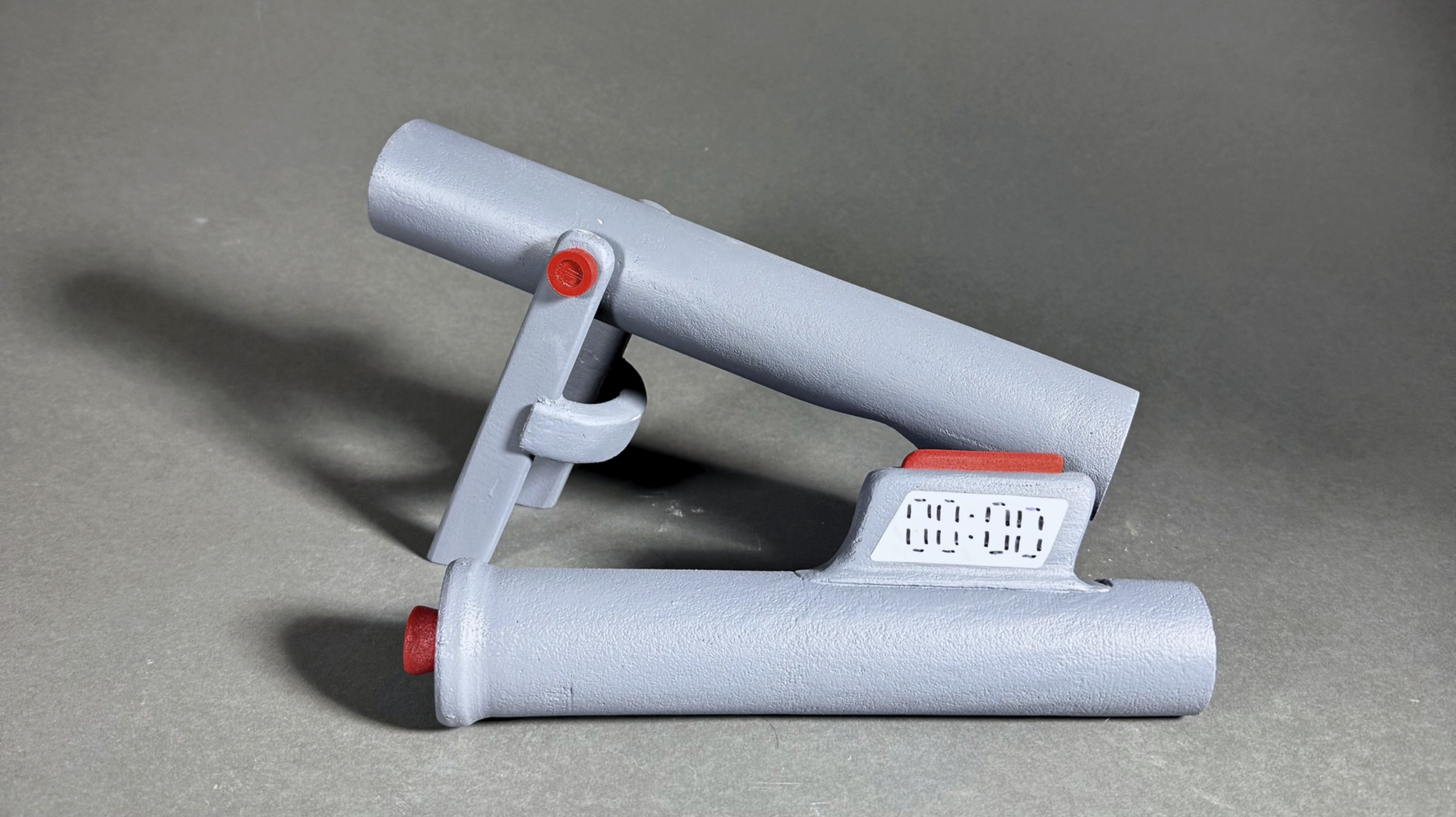 A gray digital heating pad with a timer display attached to a gray surface.