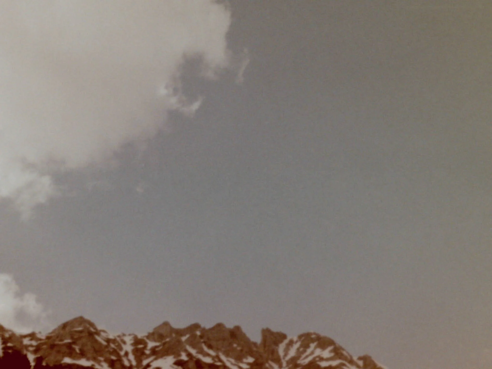 Blick auf Wolken am Himmel mit Teil eines Gebäudes im Vordergrund.
