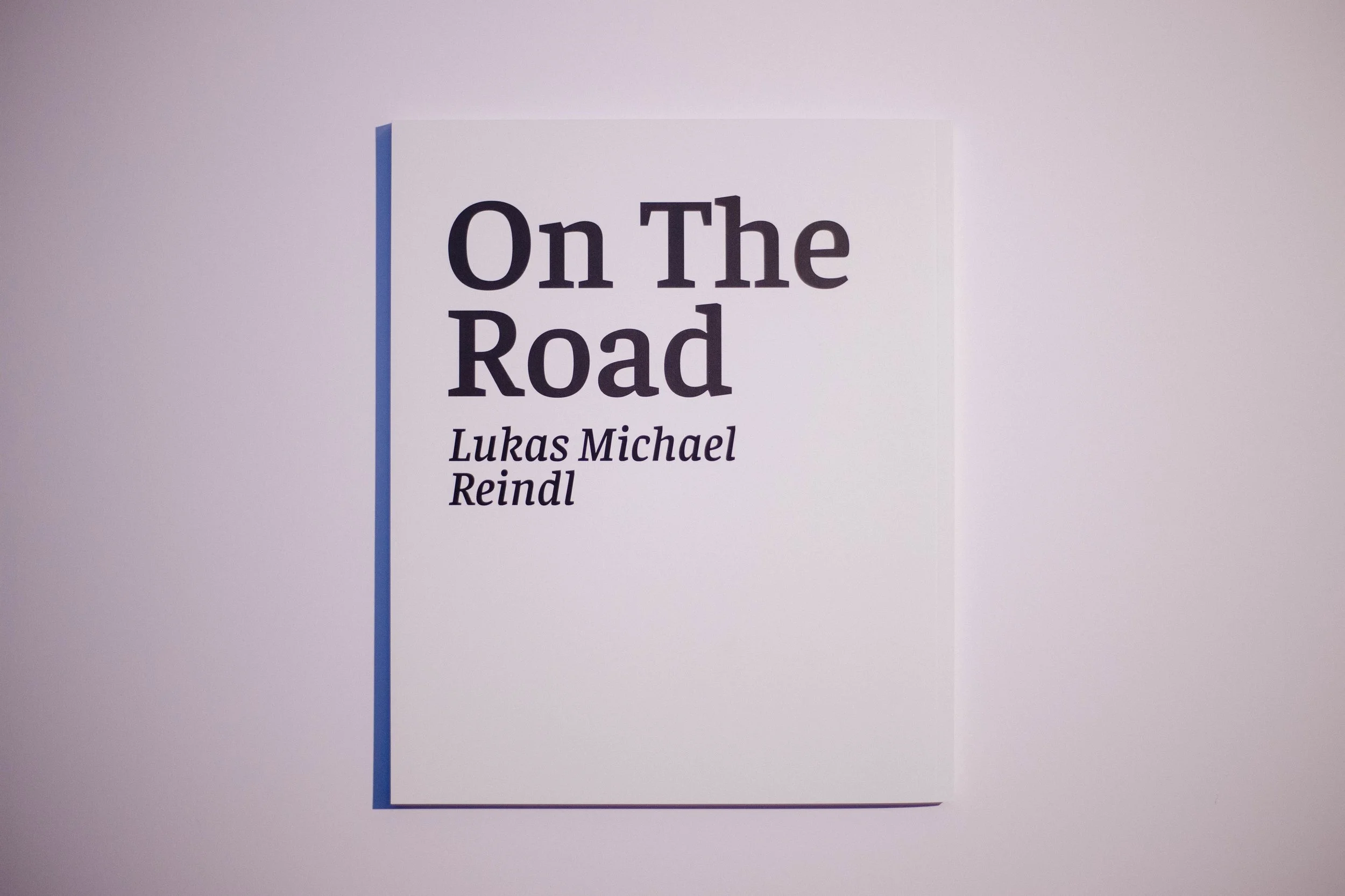 Buchplakat mit der Überschrift 'On The Road' und den Autoren Lukas Michael Reindl und.