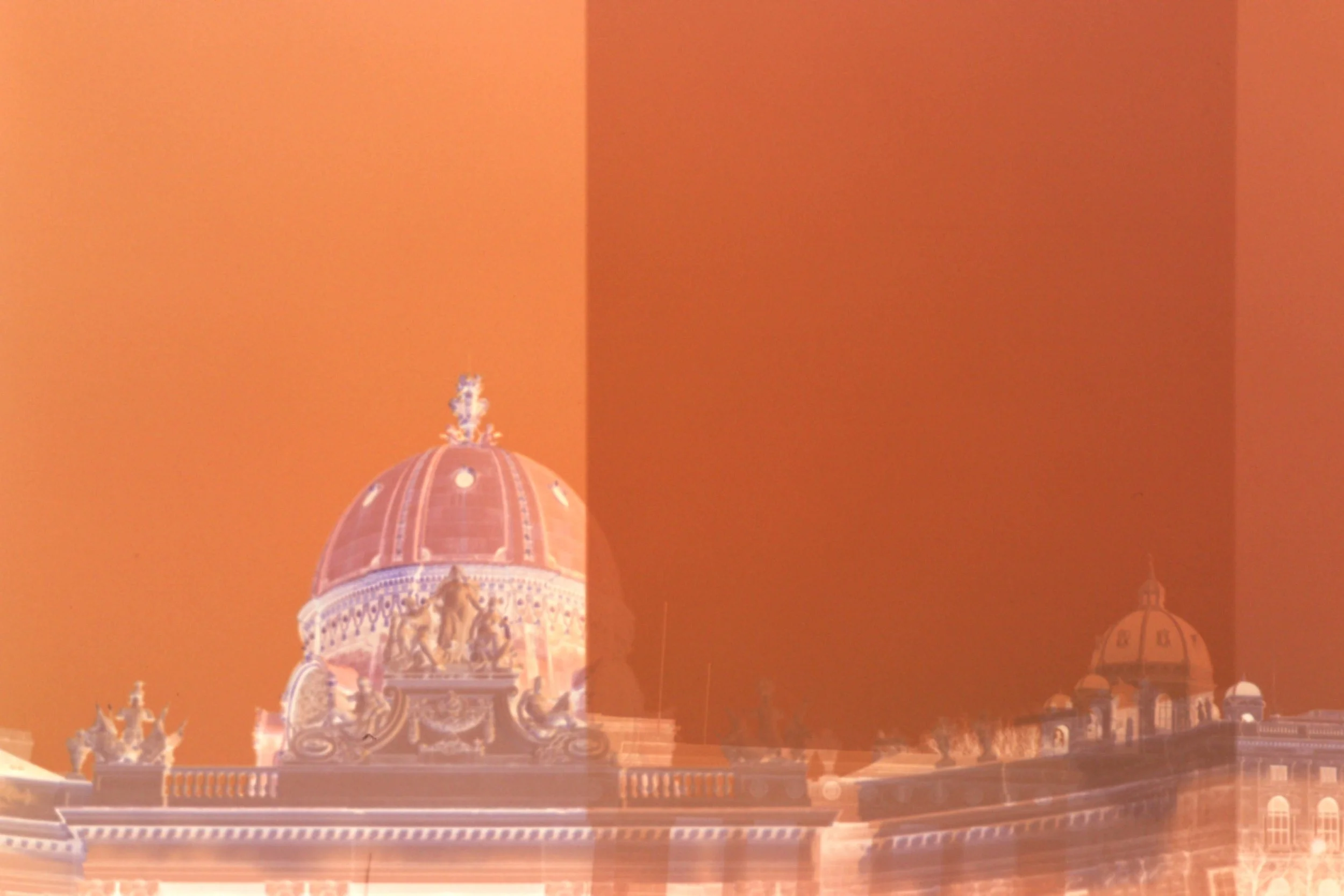 Ein Gebäude mit einer großen Kuppel, das an die Architektur des Doms von Florenz erinnert, vor einem orangefarbenen Himmel.