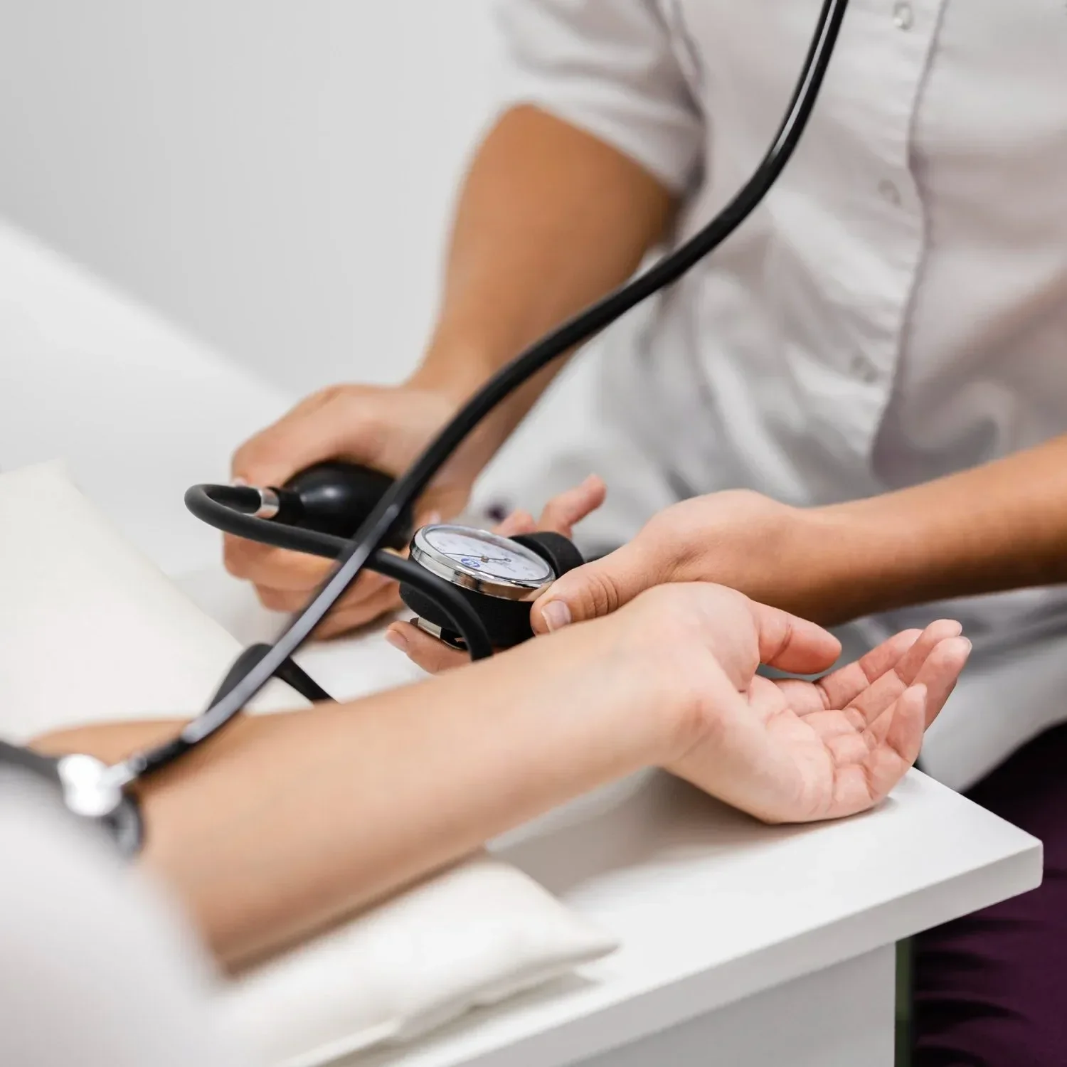 A healthcare professional measuring a patient's blood pressure with a sphygmomanometer.
