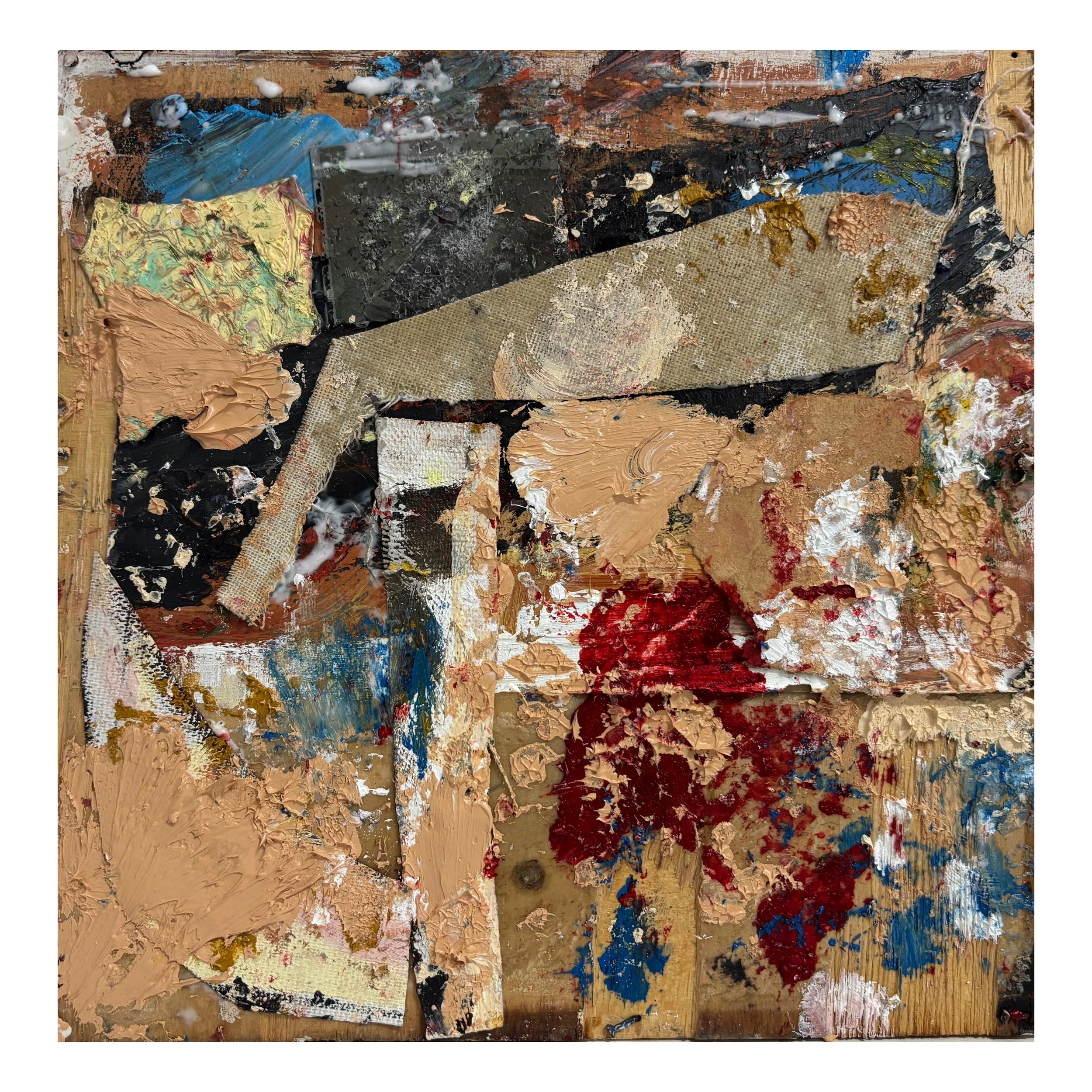 A small, rectangular abstract painting with textured, thickly applied paint in earthy tones like tan, beige, black, and brown, with accents of red, blue, and white, on a wooden surface.
