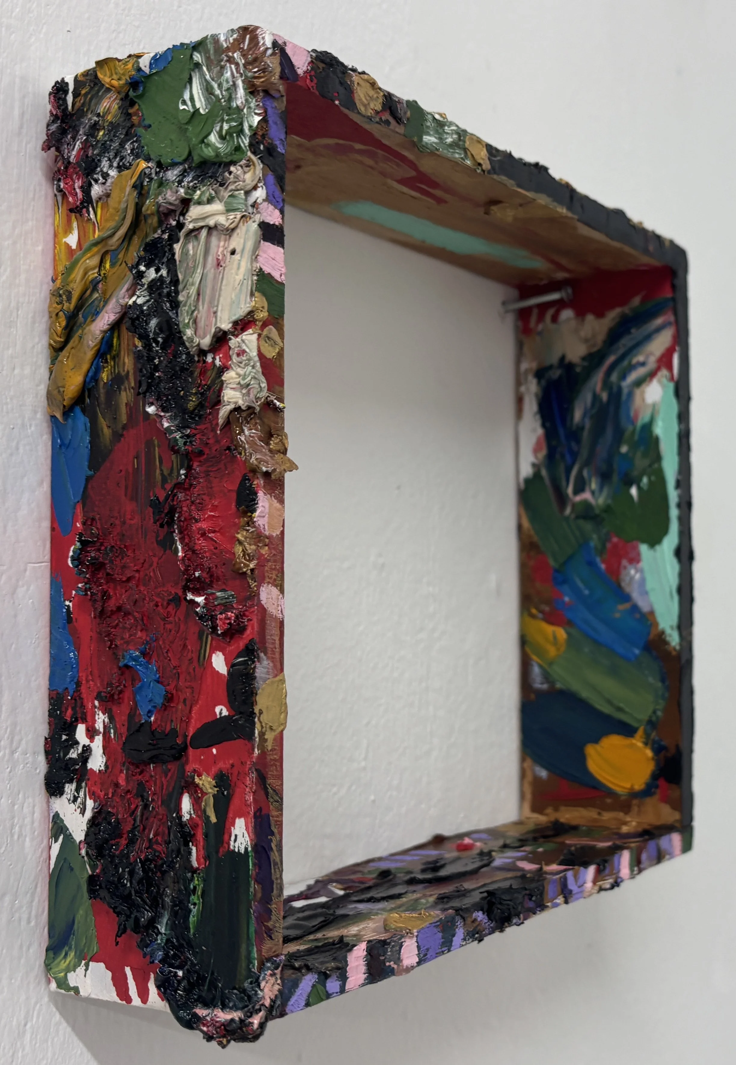 Close-up of a 3D mixed media art piece with thick, colorful paint and textured layers on a rectangular canvas.