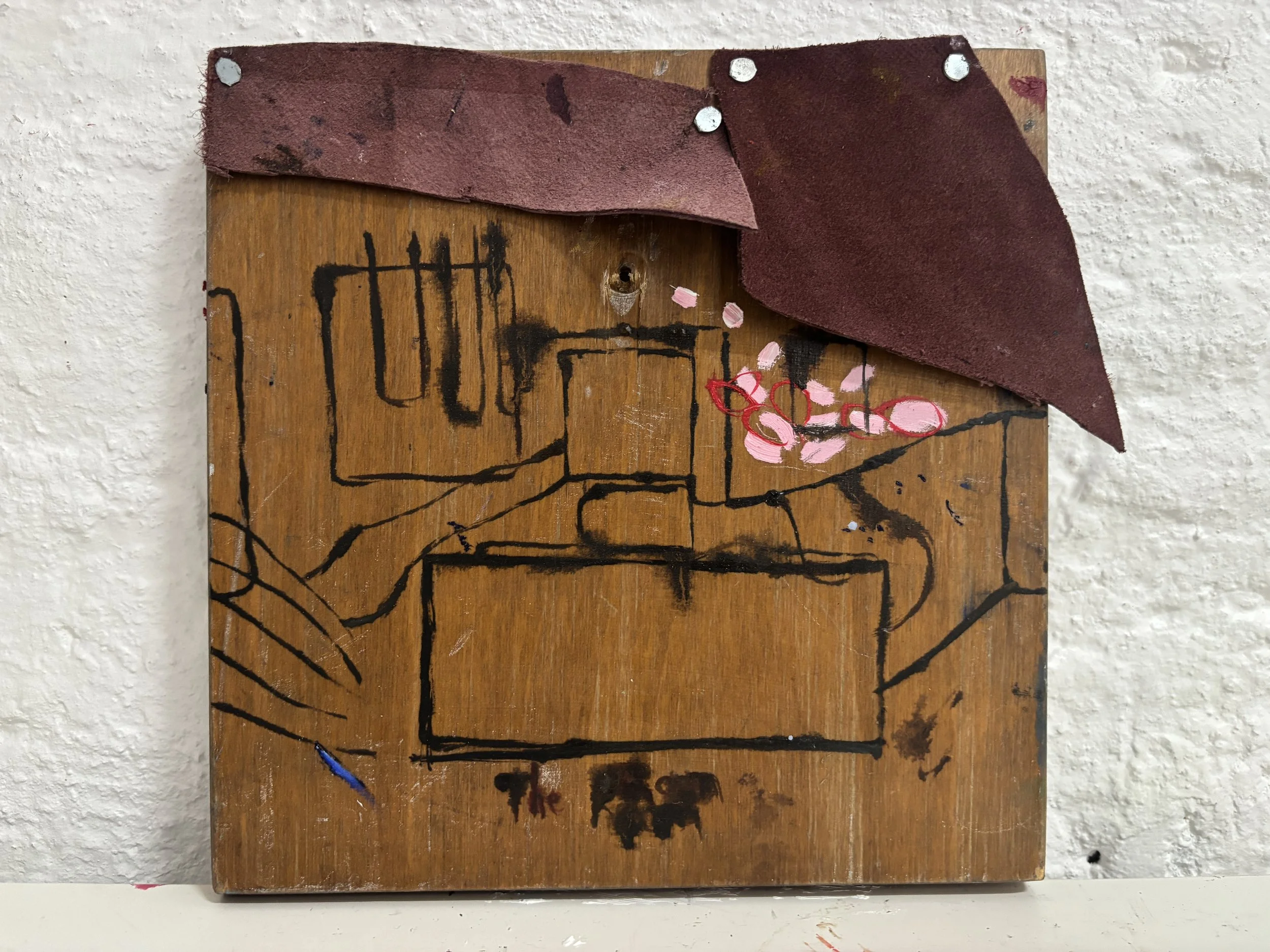 Artistic wall decoration with a wooden panel featuring a black line drawing of a hand holding a cup, pink and red painted cherry blossoms, and an attached red leather piece with scattered silver nails.
