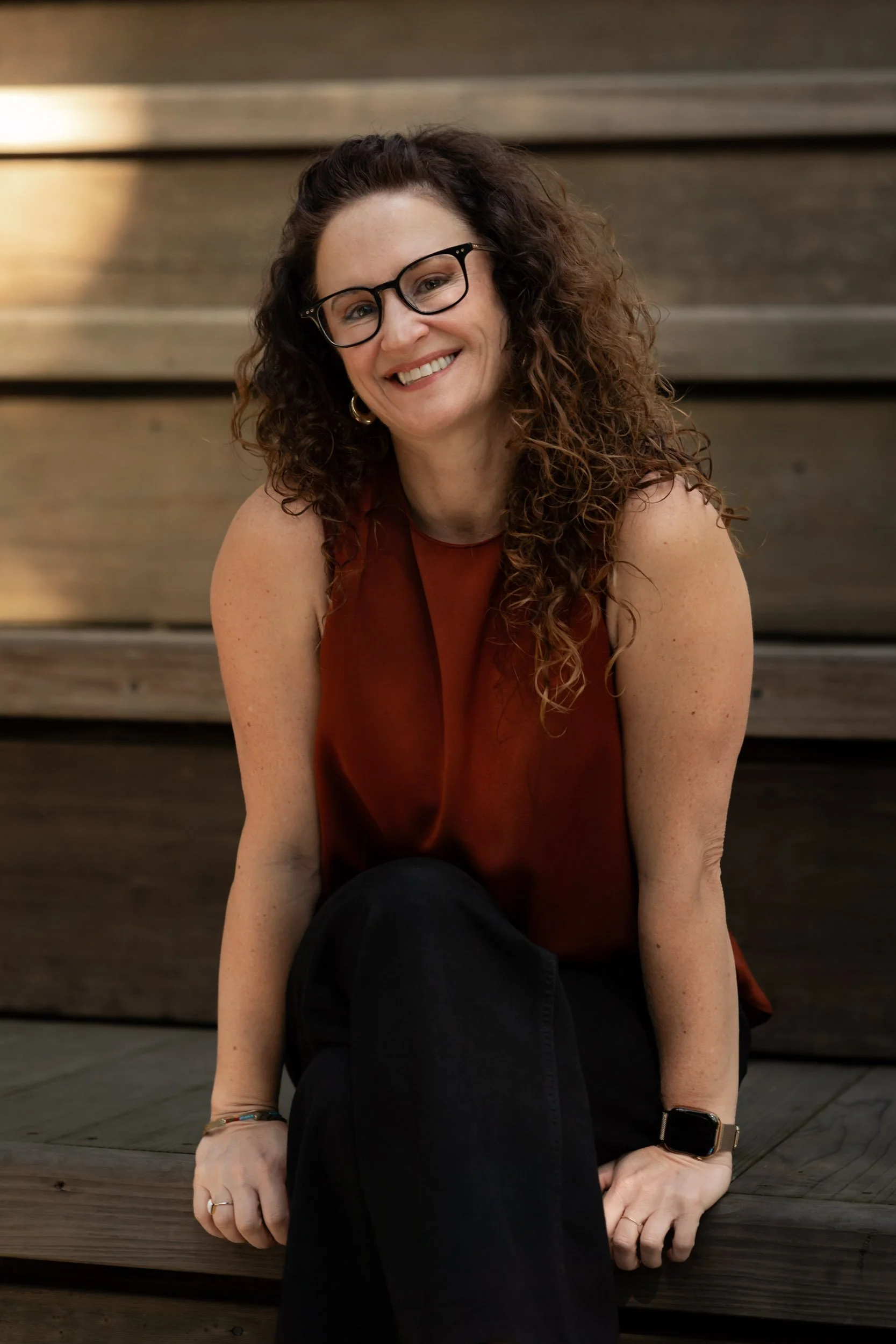 Ellie Vargas, LCSW, Certified IFS Therapist and IFSI Approved Consultant smiling seated outdoors.