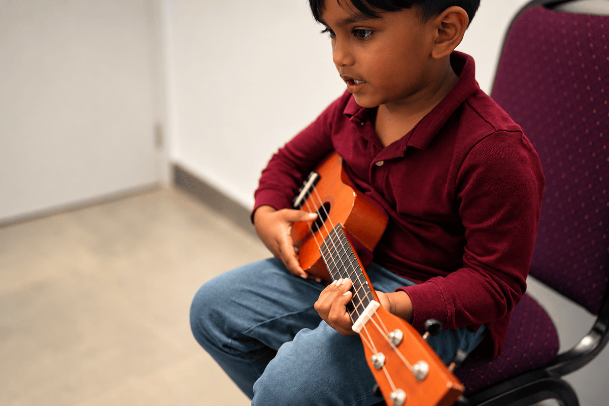 Young student learning a string instrument at Little Chopin Academy