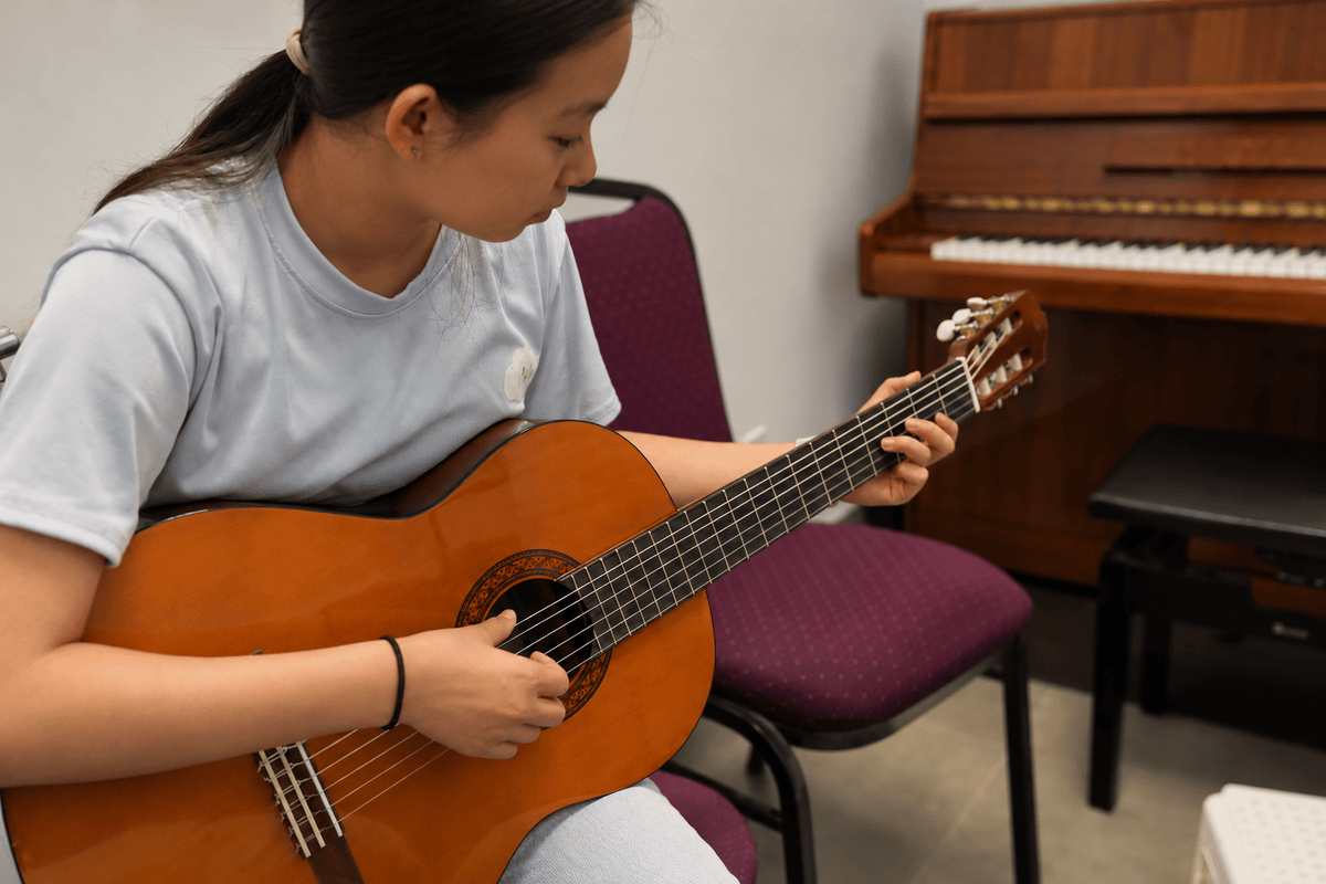 Student learning classical guitar at Little Chopin Academy