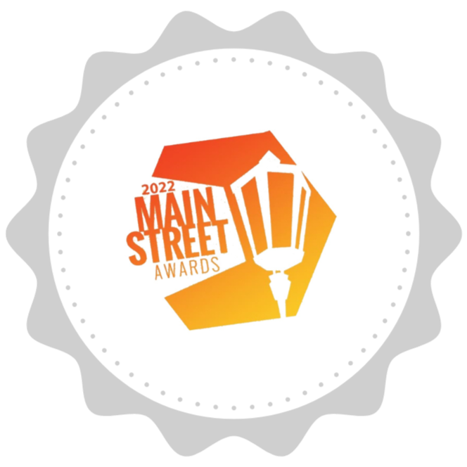Logo for the 2022 Main Street Awards featuring a stylized streetlamp, a building, and text in orange and red.