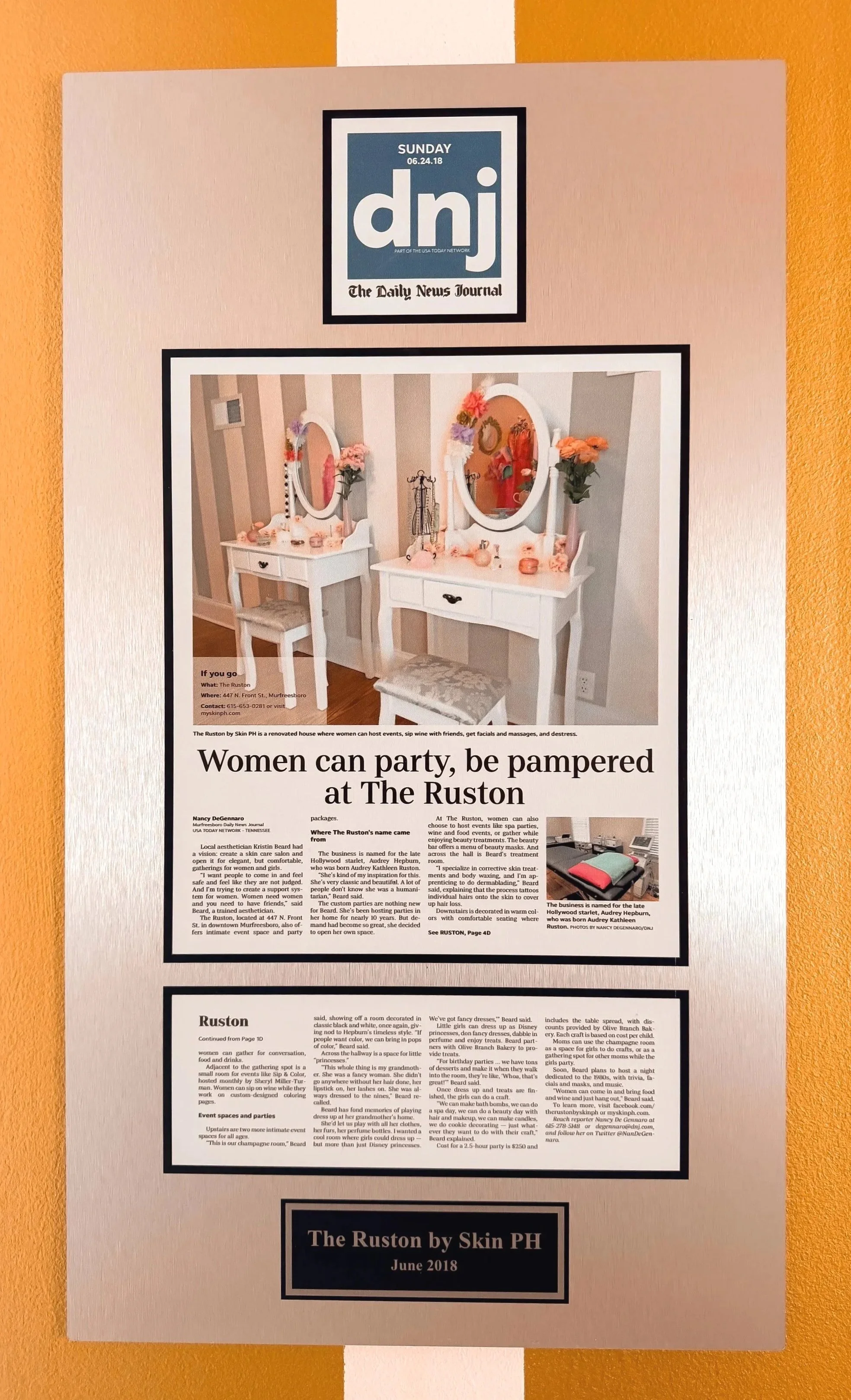 A newspaper article titled 'Women can party, be pampered at The Ruston' features a photo of a vanity table with pink flowers, mirrors, and makeup items, set against a striped wallpaper background. The article discusses activities and events at The Ruston, a house where women host gatherings and enjoy spa services.