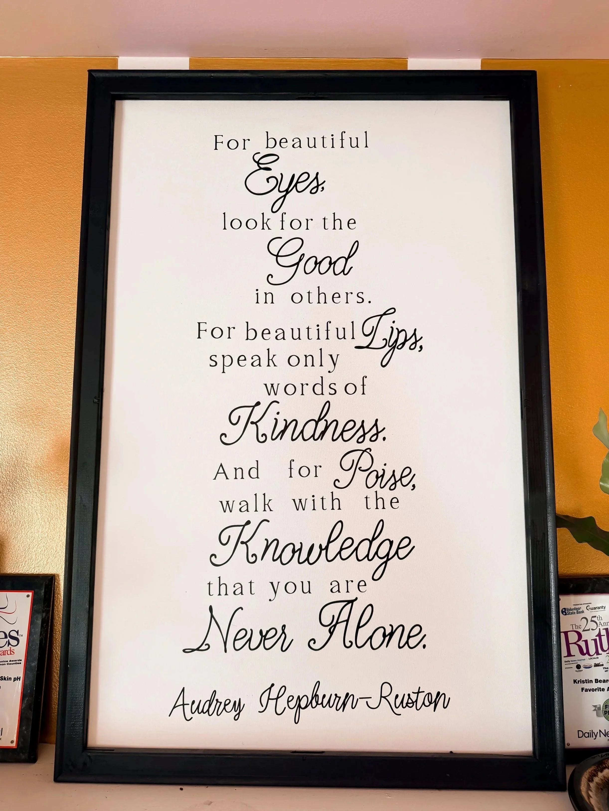 Framed quote with black text on a white background, reading 'For beautiful eyes, look for the good in others. For beautiful lips, speak only words of kindness. And for never alone, walk with the knowledge that you are never alone.'