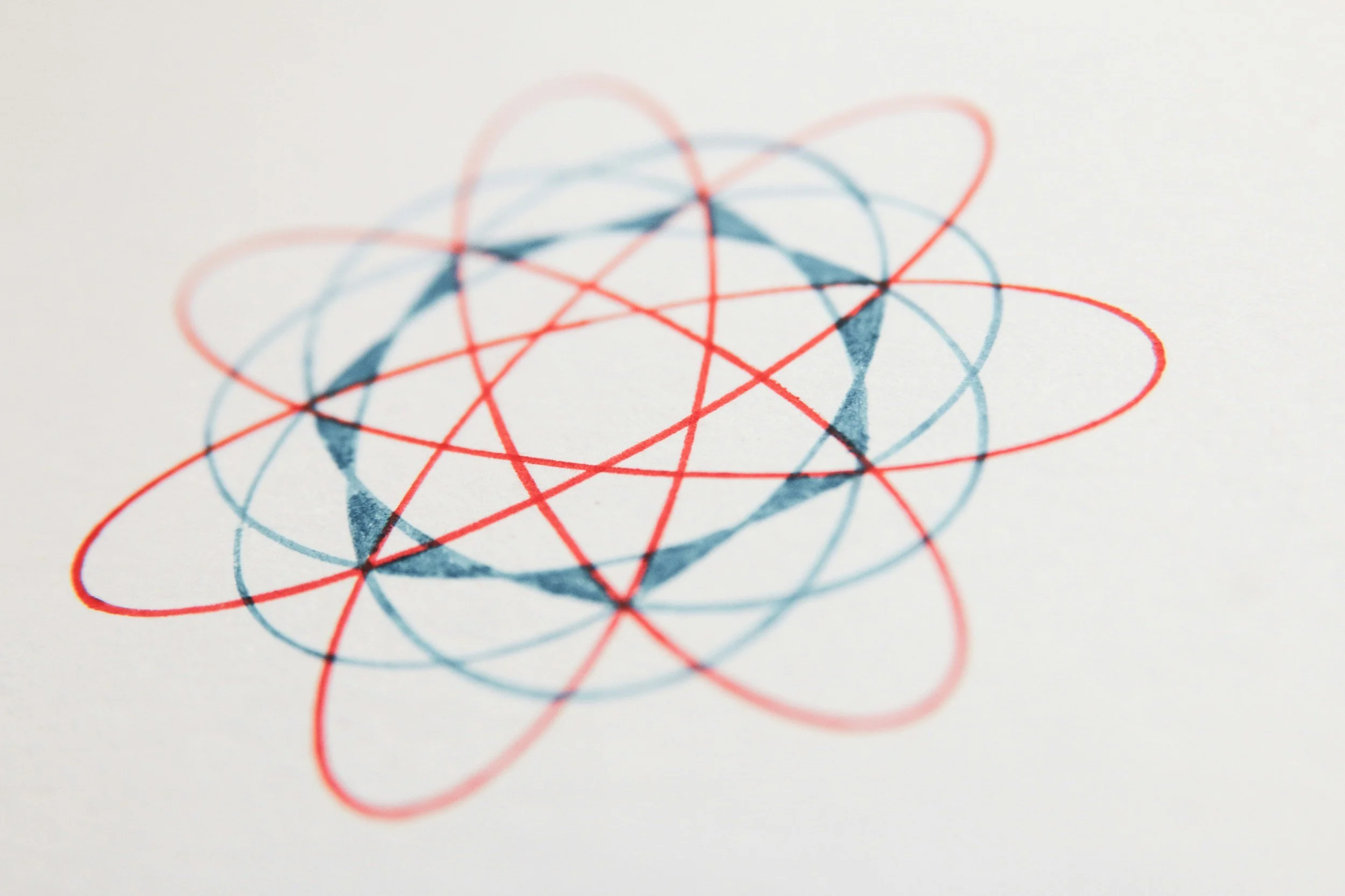 Close-up of a drawing with overlapping blue and red circles and lines on a white surface.