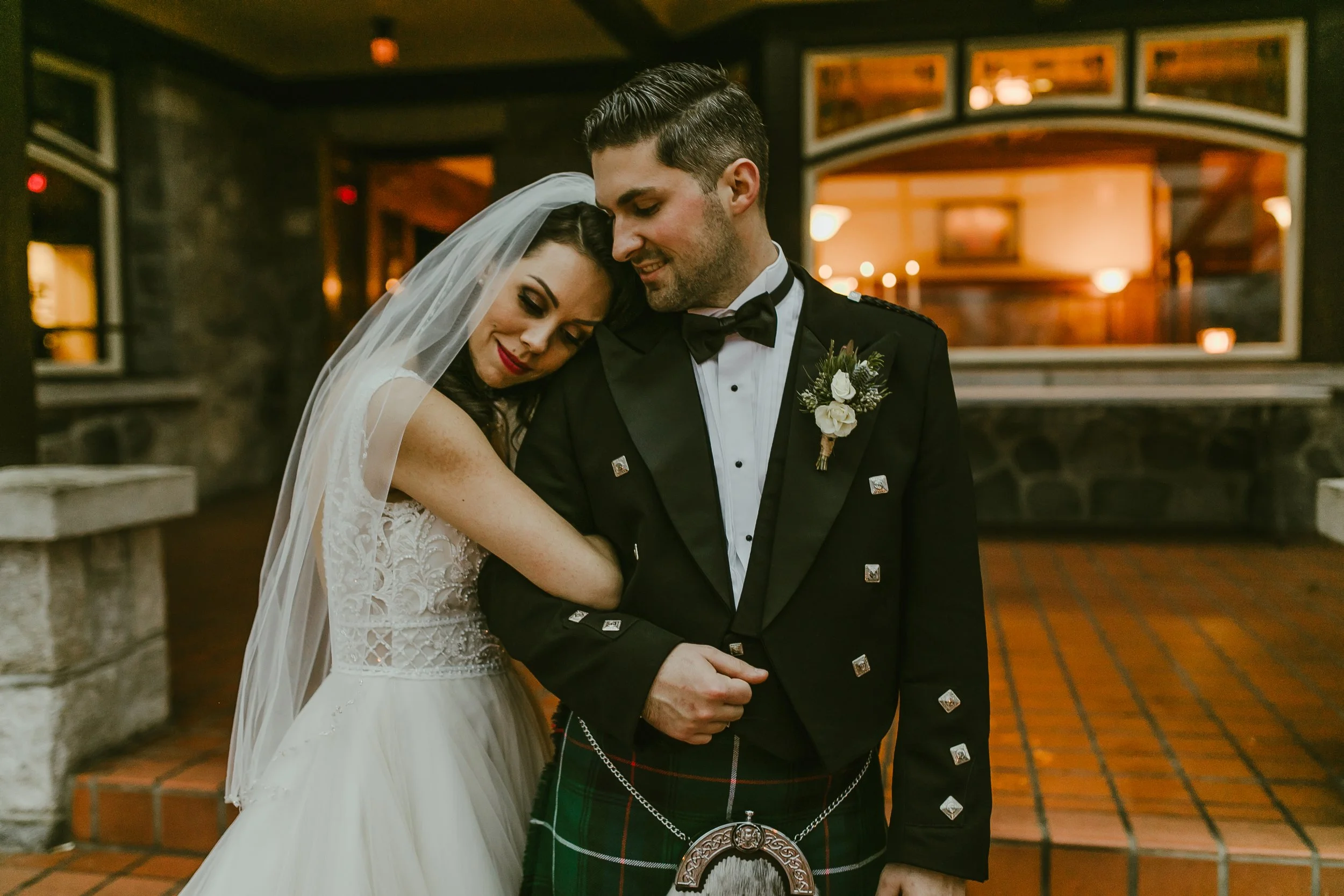 Bride and groom in a tartan kilt embrace at their Fraser Valley reception