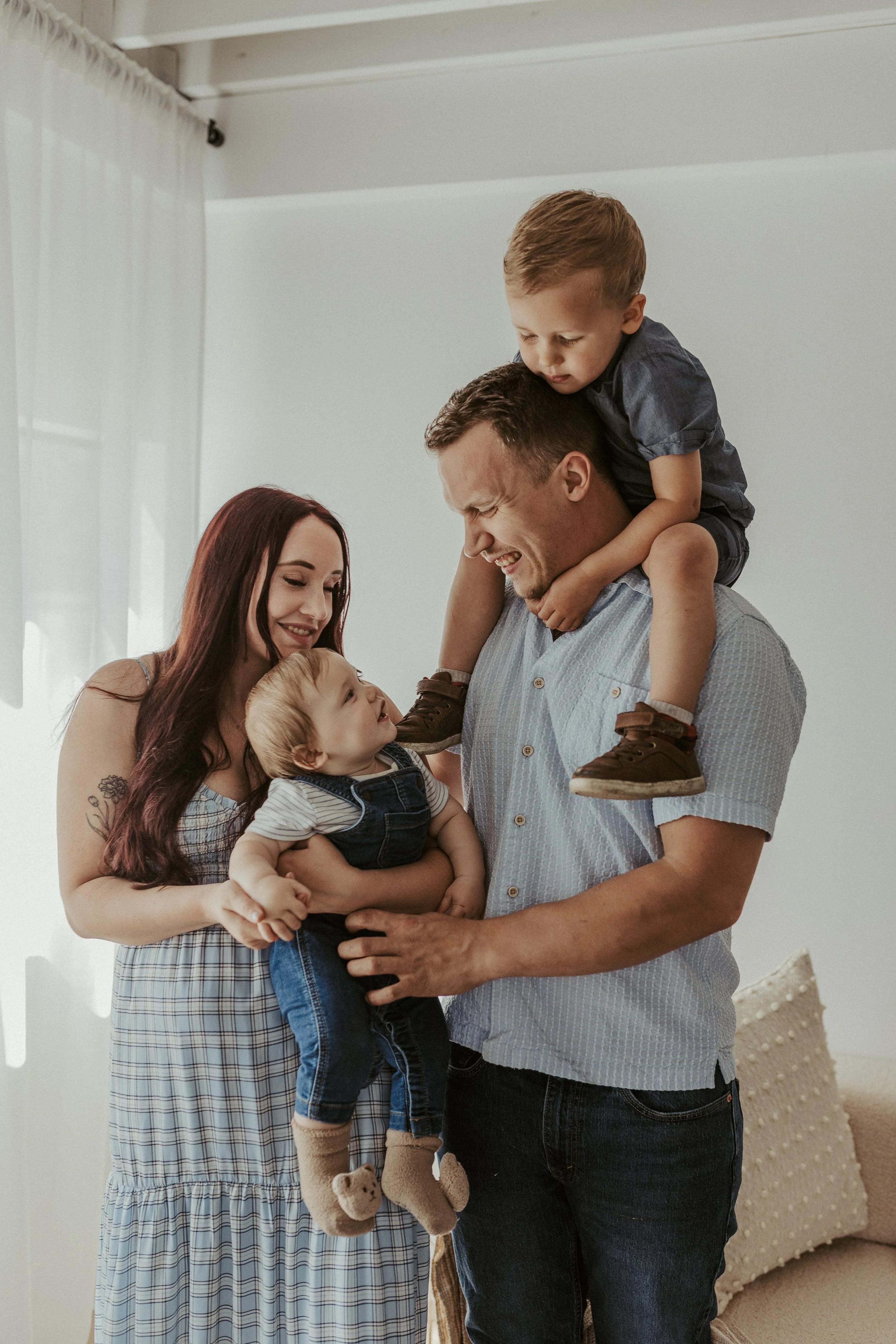 Family of four at home, dad with his son up on his shoulders