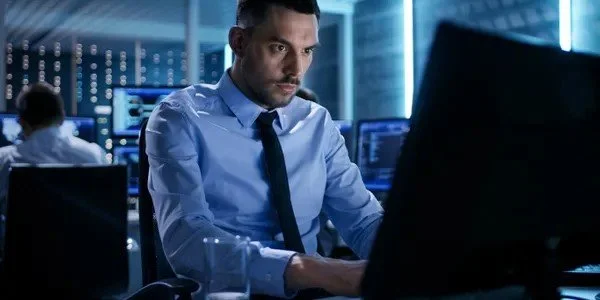 Investigator working on a computer in a high-tech office environment.