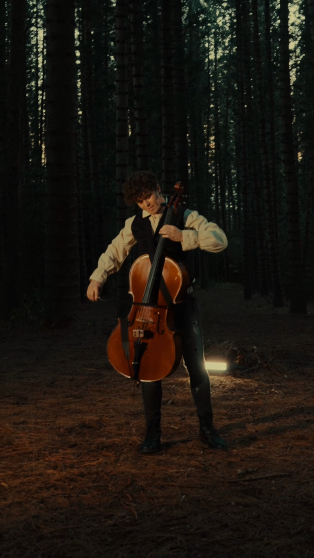 Lovejack holding a cello in a Bridgerton-inspired performance outfit.