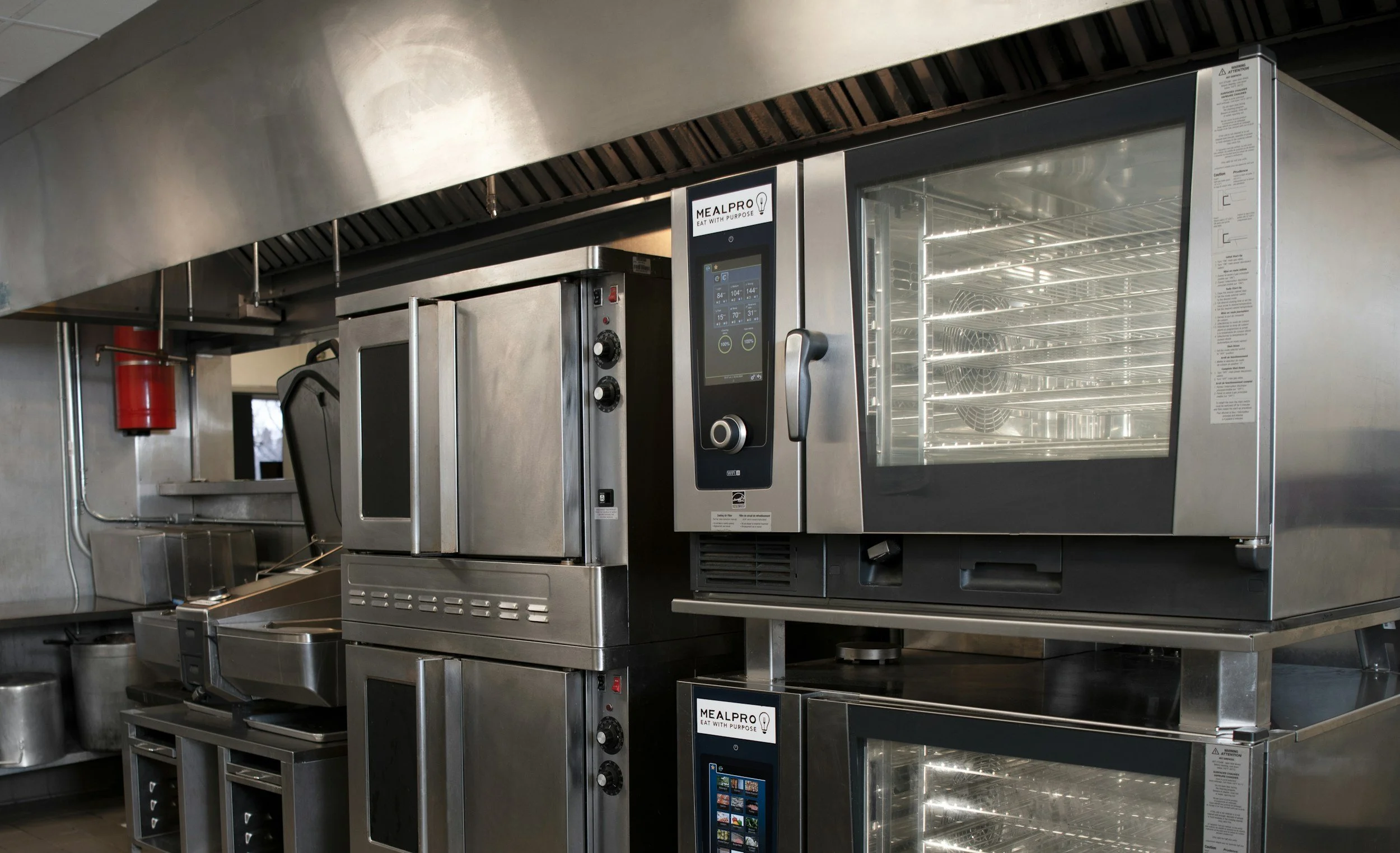 Commercial kitchen appliances including an oven and a food warmer with digital display and a glass door.