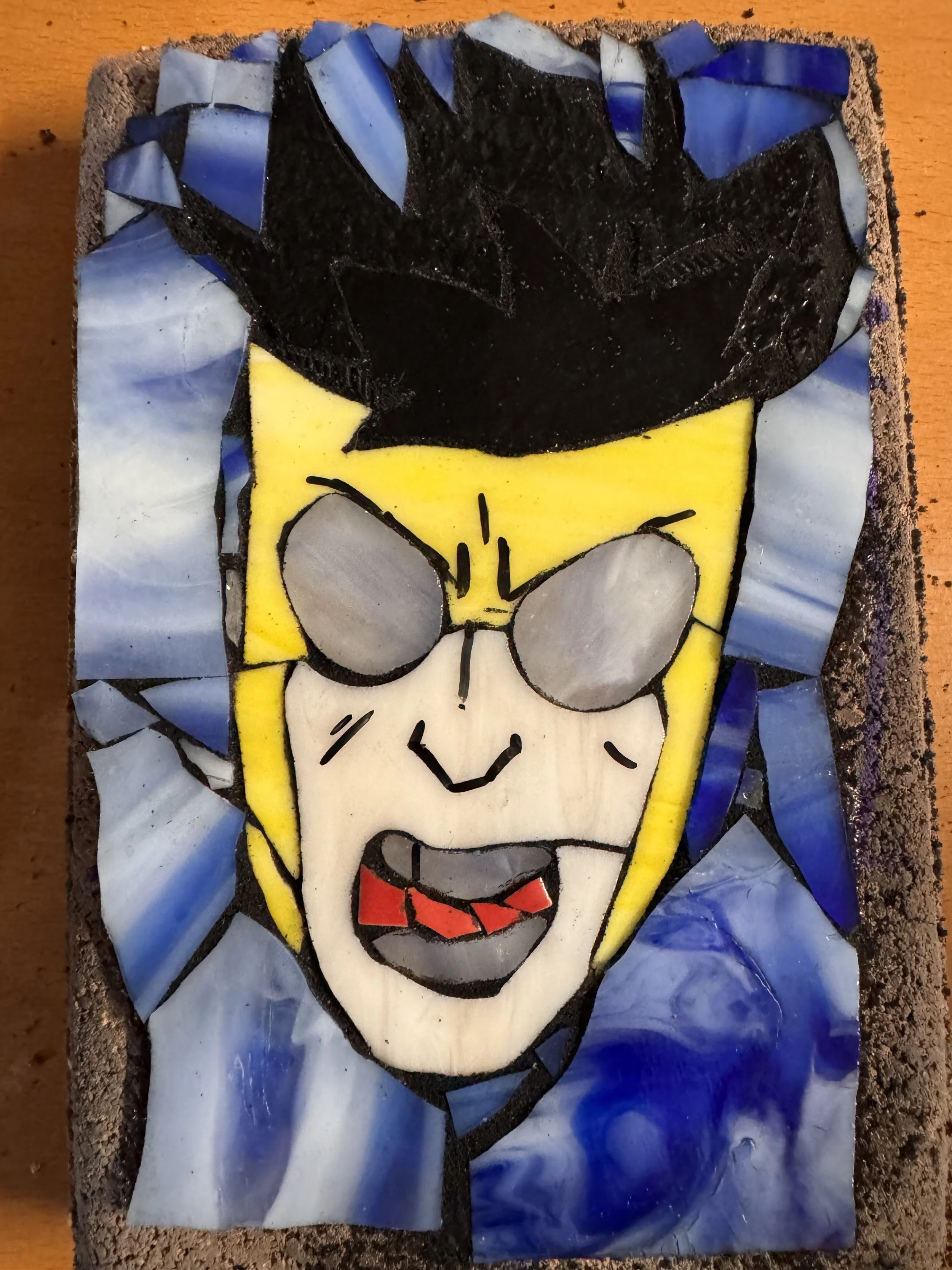 A mosaic art piece of SpongeBob SquarePants, with blue background and yellow face, black outlines, and red tongue.