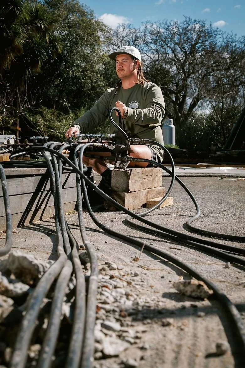 Greenway Construction specialist operating a unified hydraulic jacking manifold system for precise house releveling and foundation repair in Christchurch