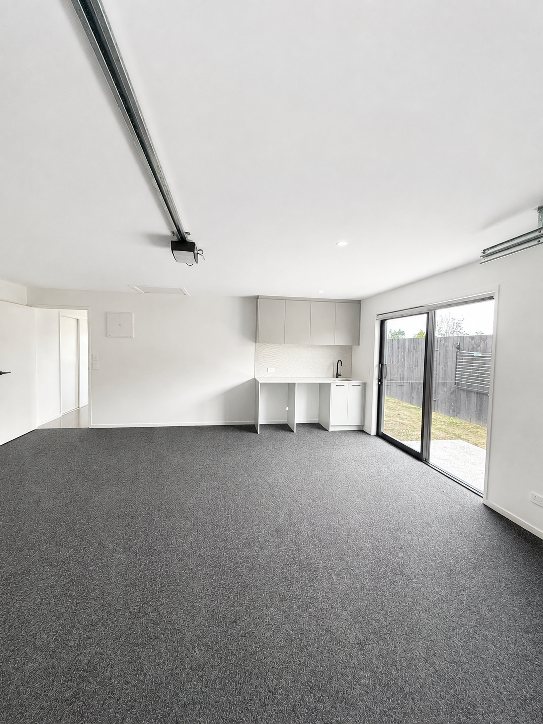 Carpeted garage in completed Benchmark Build home in Mangawhai