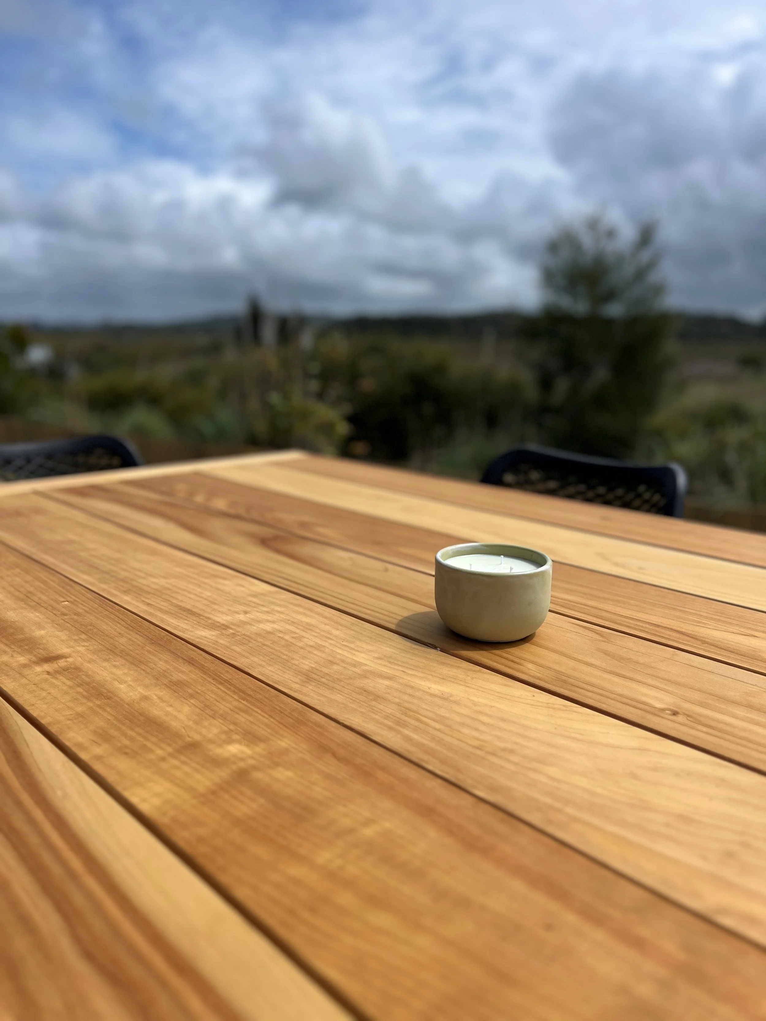 Close-up of Homestead Macrocarpa dining table showing the natural timber grain and smooth oil-finished tabletop.