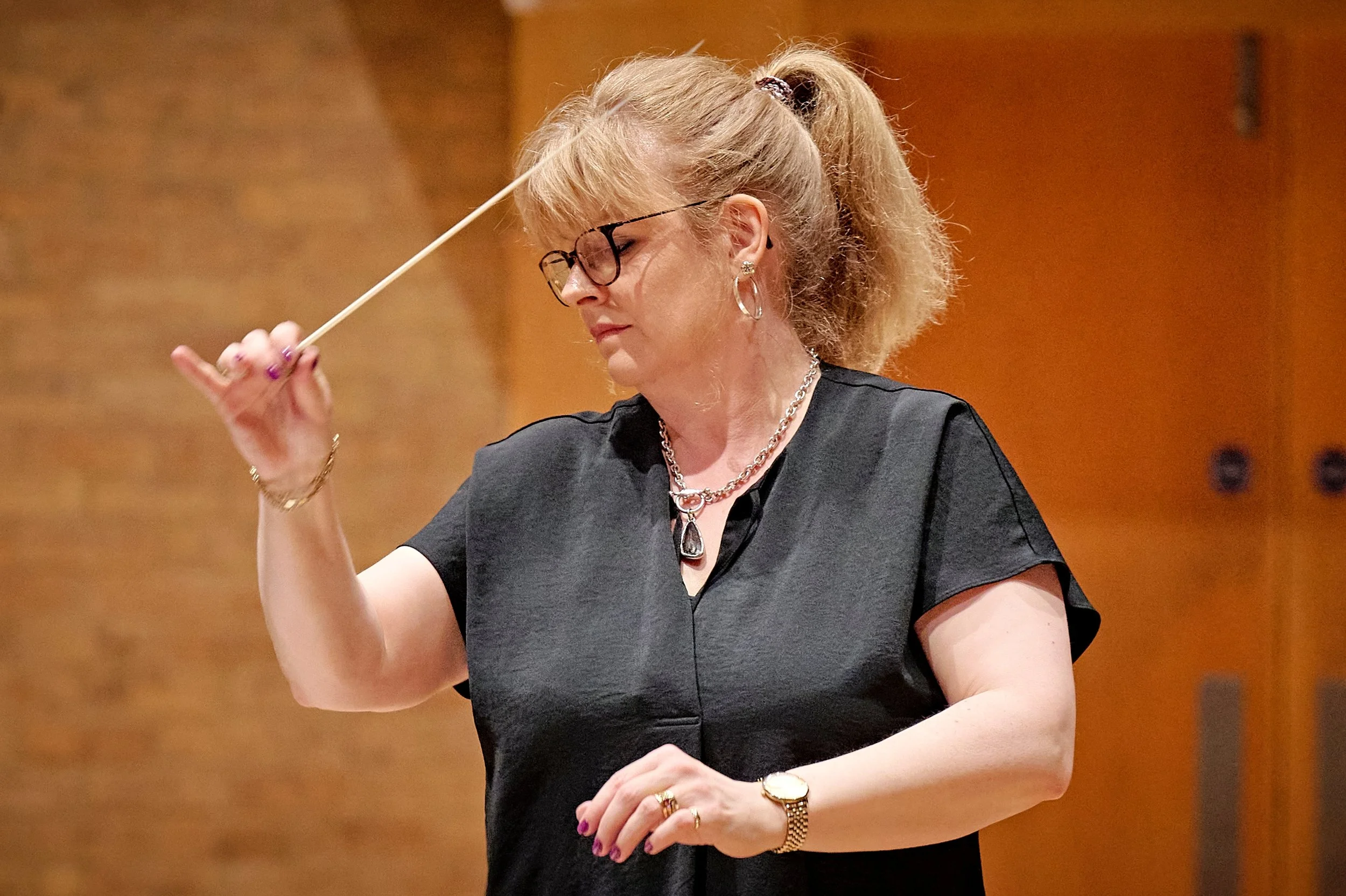 Female conductor a symphonic wind band and musical performance.