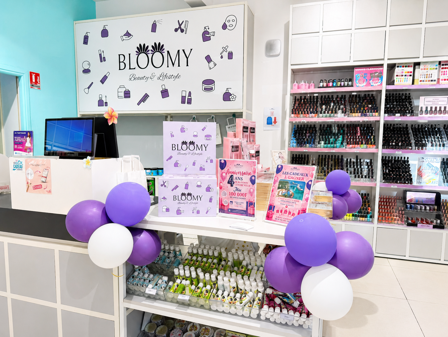 Vitrine de boutique de beauté avec produits pour les ongles, vernis à ongles, accessoires, décorations en ballons violets et blancs, et affiches promotionnelles.
