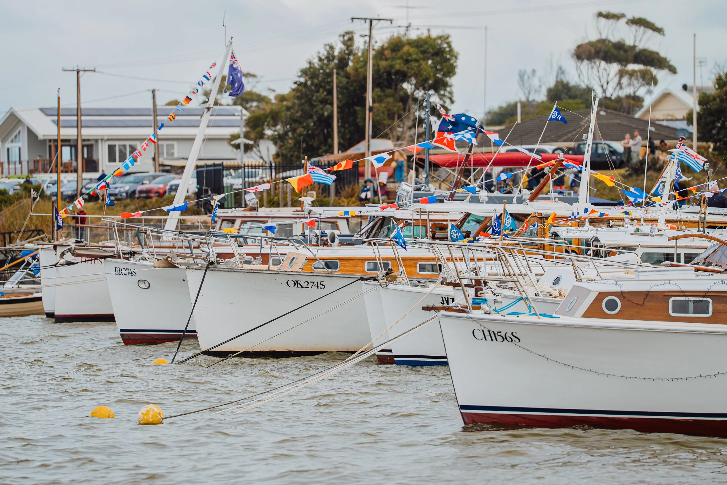 Several boats docked near the Wharf decorated with colourful flags.