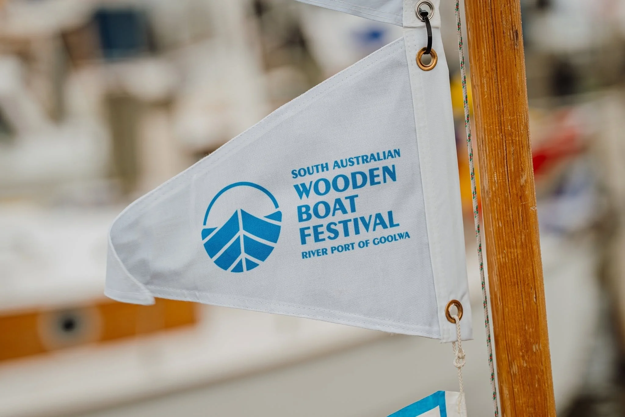 Flag for the South Australian Wooden Boat Festival hanging on a wooden pole.