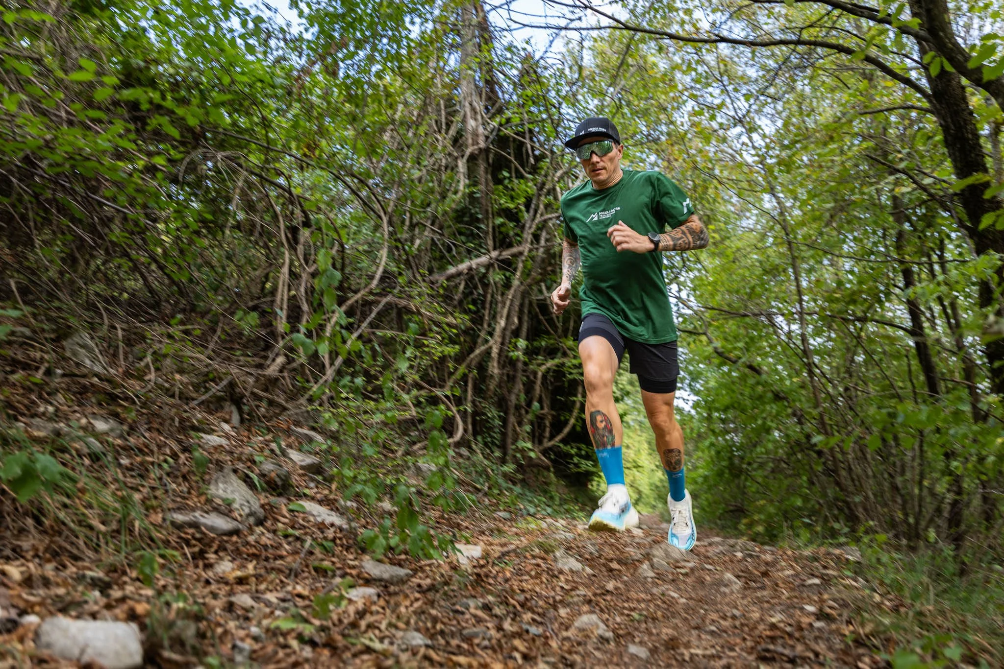Uomo che corre su un sentiero sterrato in una zona boschiva durante il giorno.