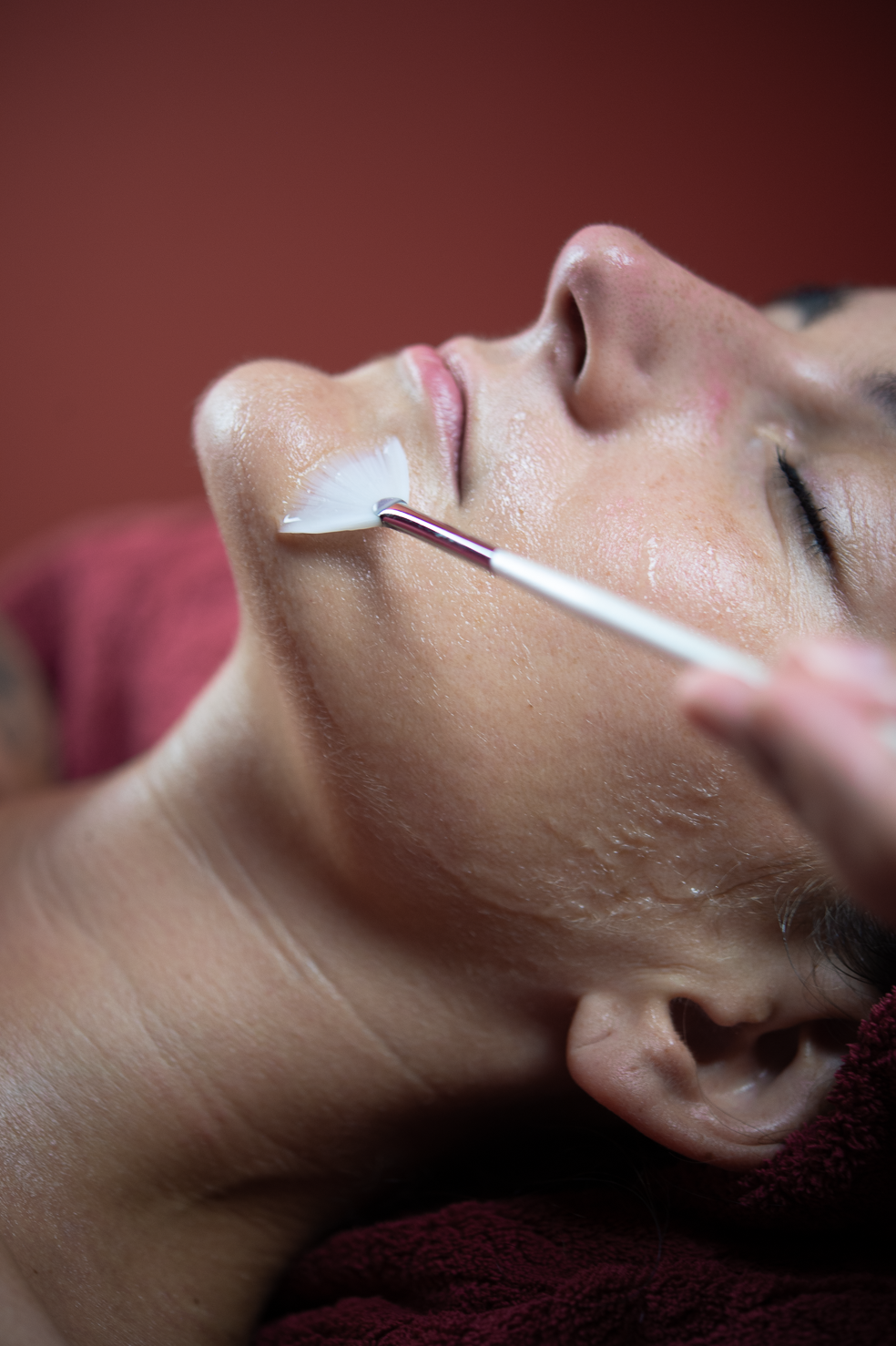 Close-up of a client's face during a Ponsarin Clinic PCA skin detox peeling treatment, with a peeling mask applied.