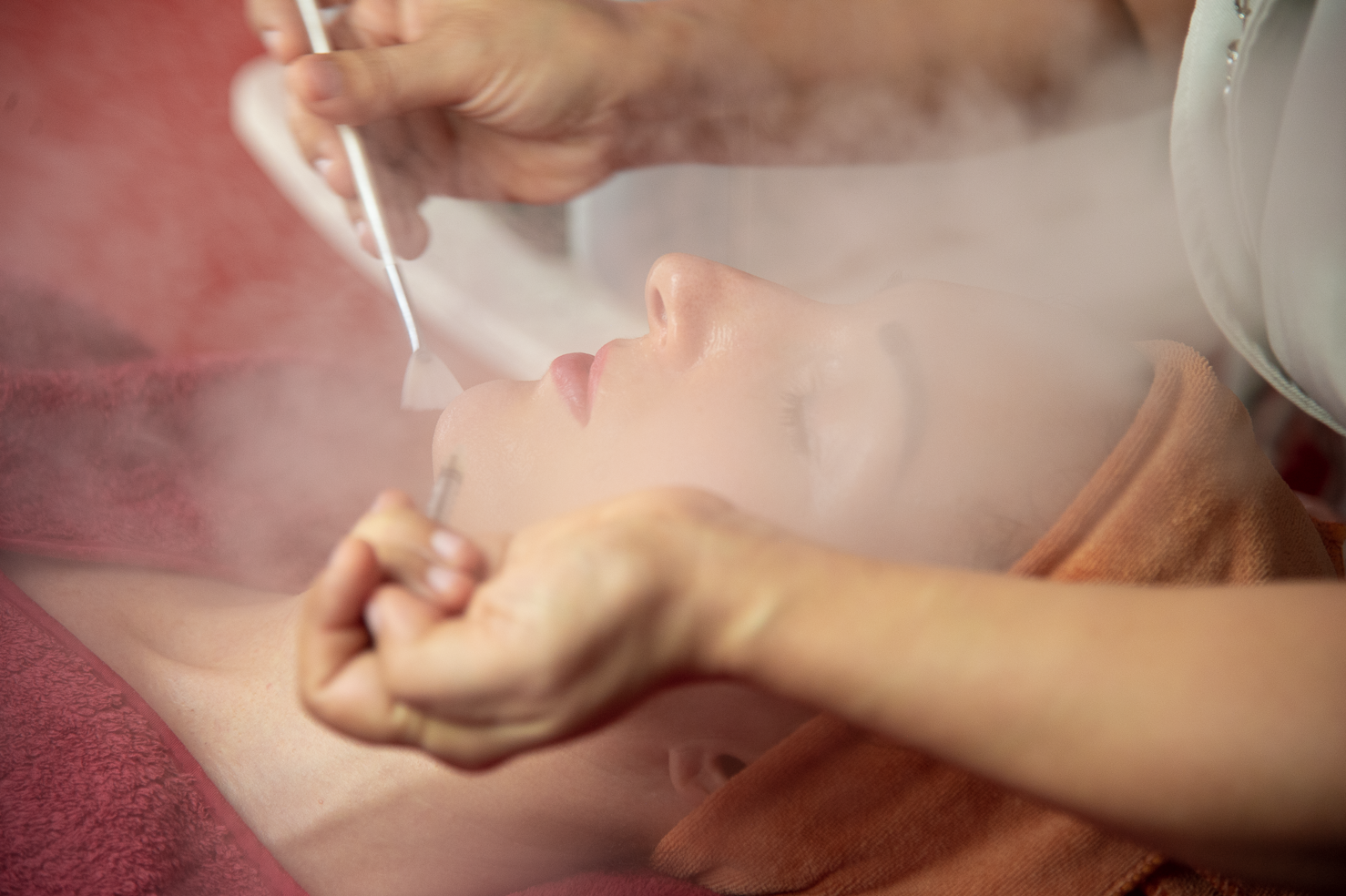 Close-up of a therapist applying a peeling treatment to a client's face at Ponsarin Clinic.