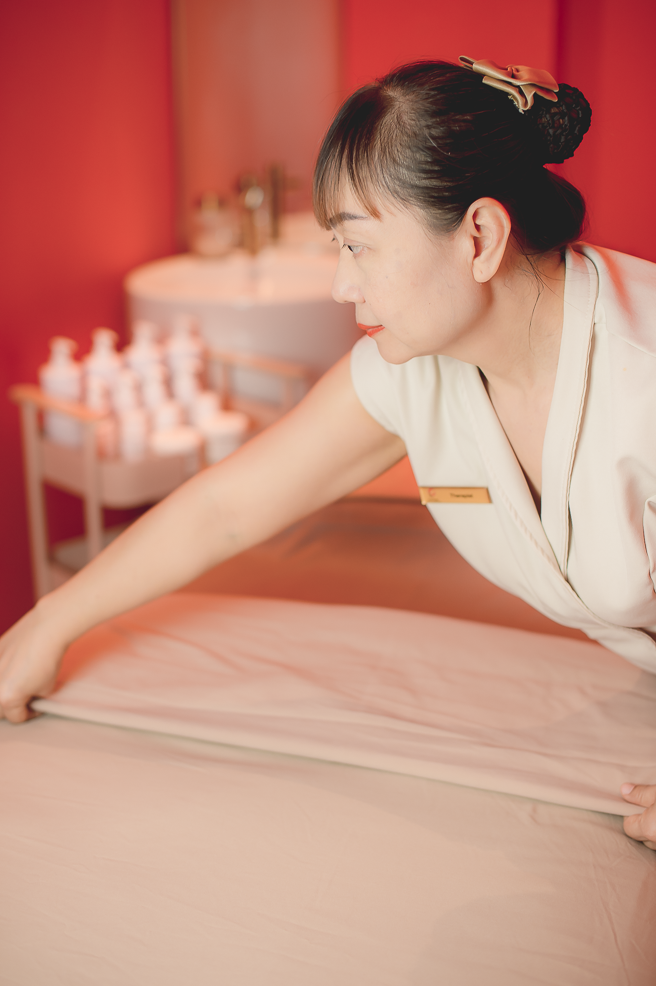 Ponsarin Clinic therapist preparing towels and linens in a private treatment cabin.
