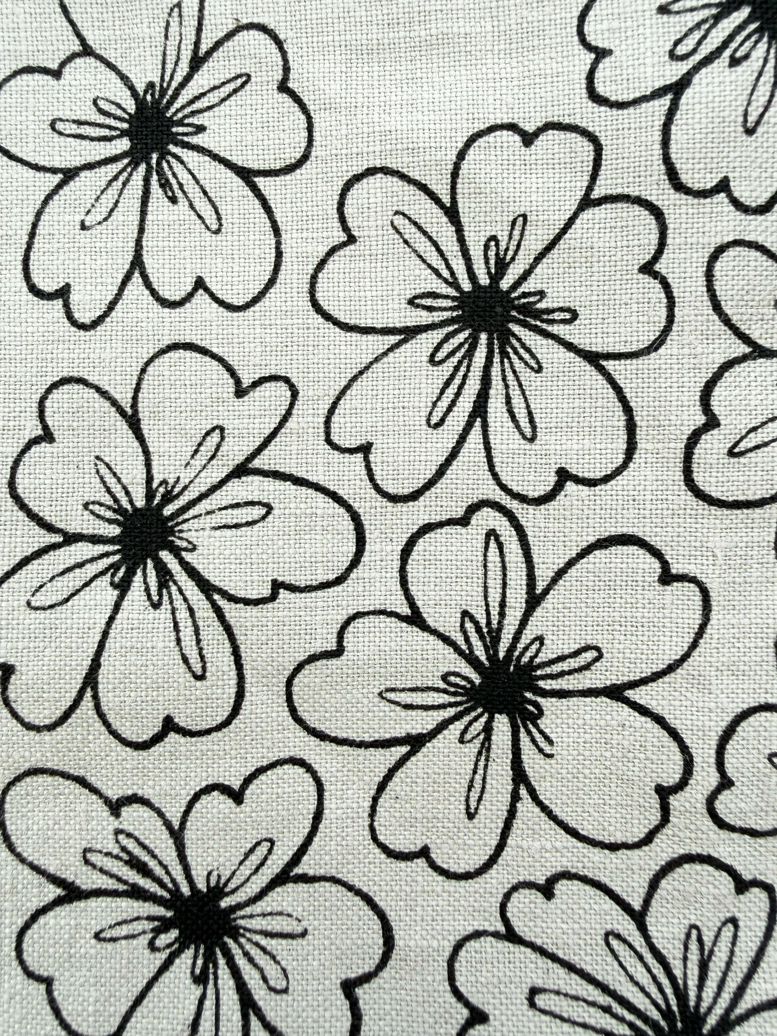 Svart- och vit blommönster med enkla konturer på tyg.