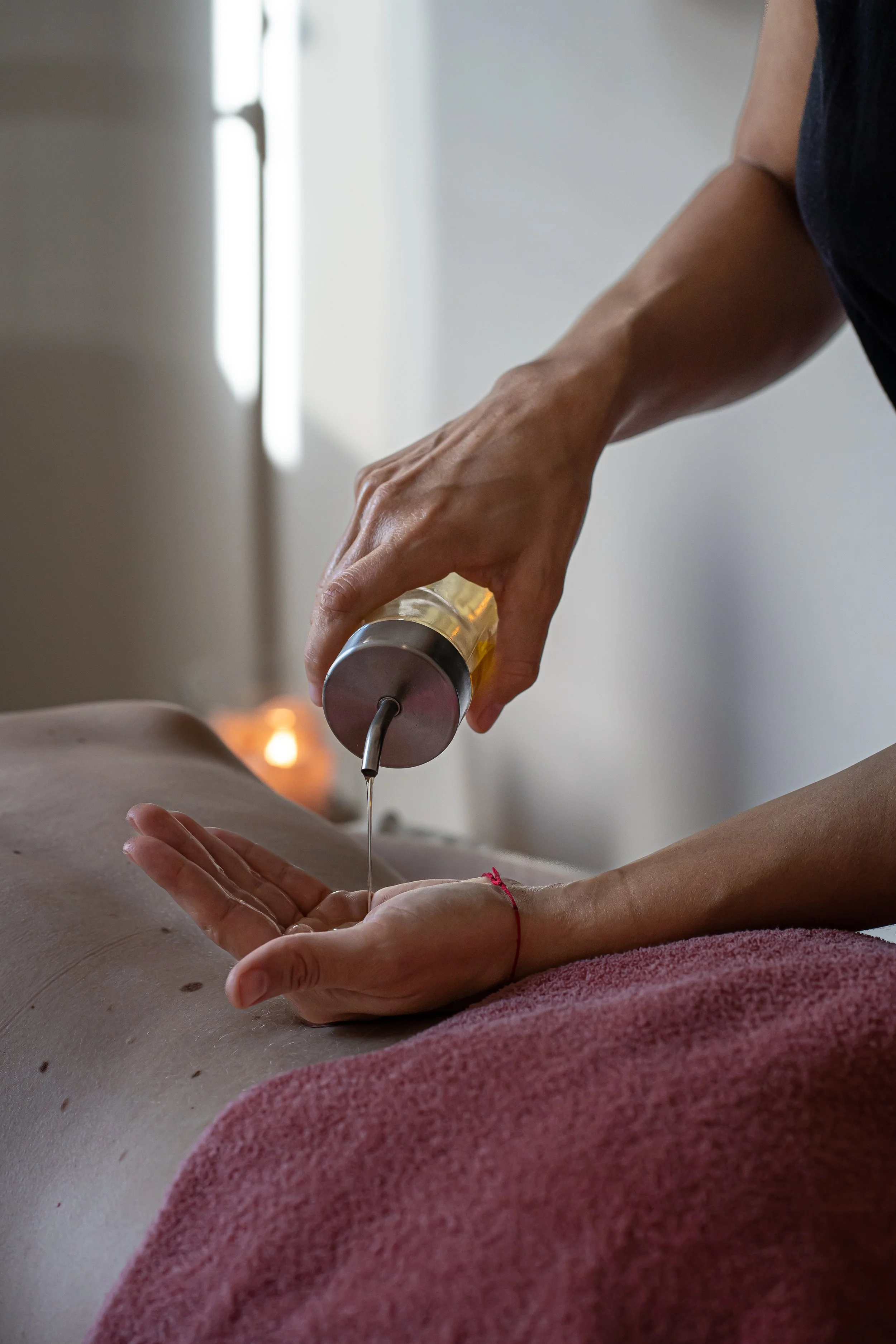Eine Person erhält eine ayurvedische Massage im Rückenbereich, die Praxis ist ruhig und professionell.