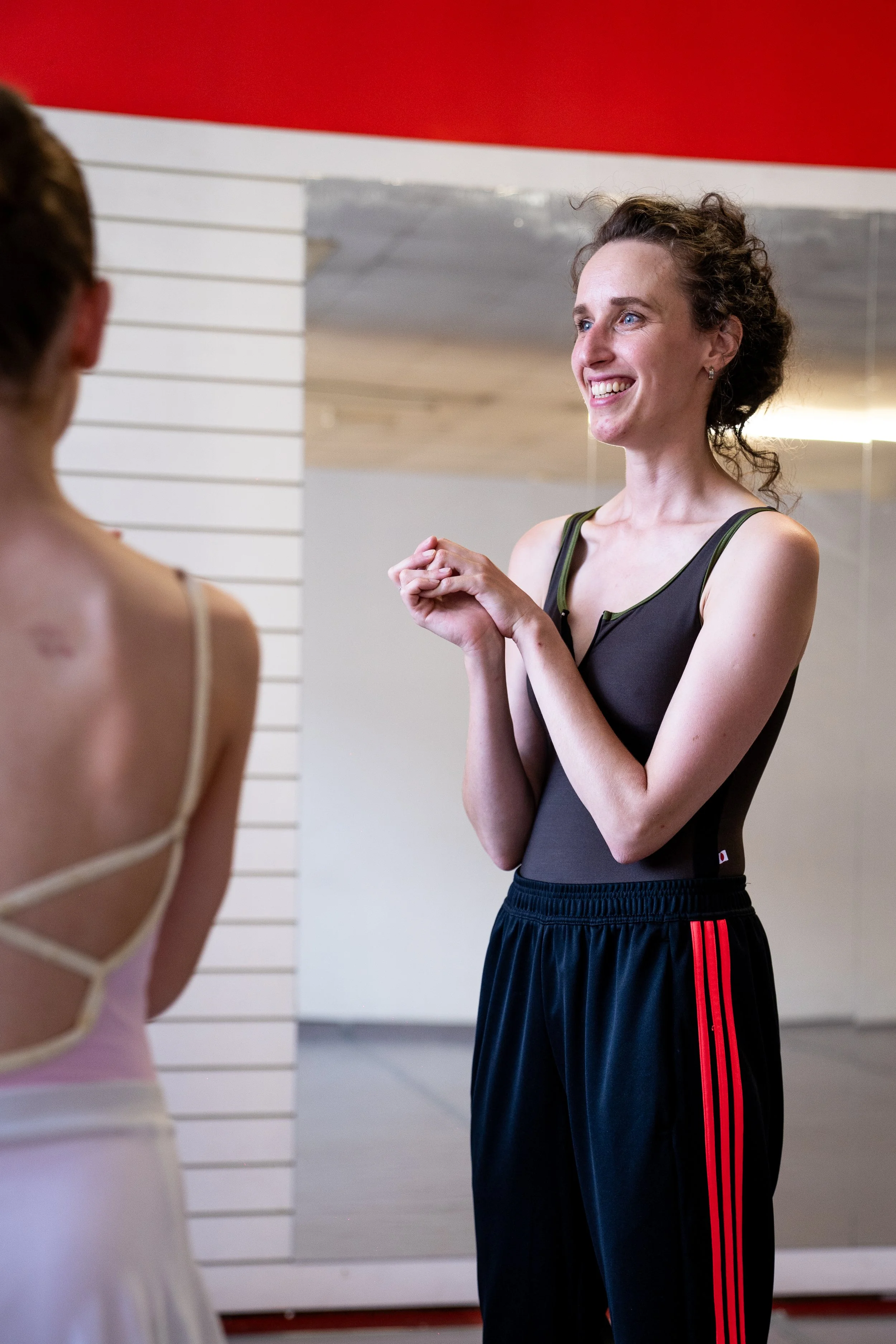 Ballet coach speaking with a dancer during a studio training session.