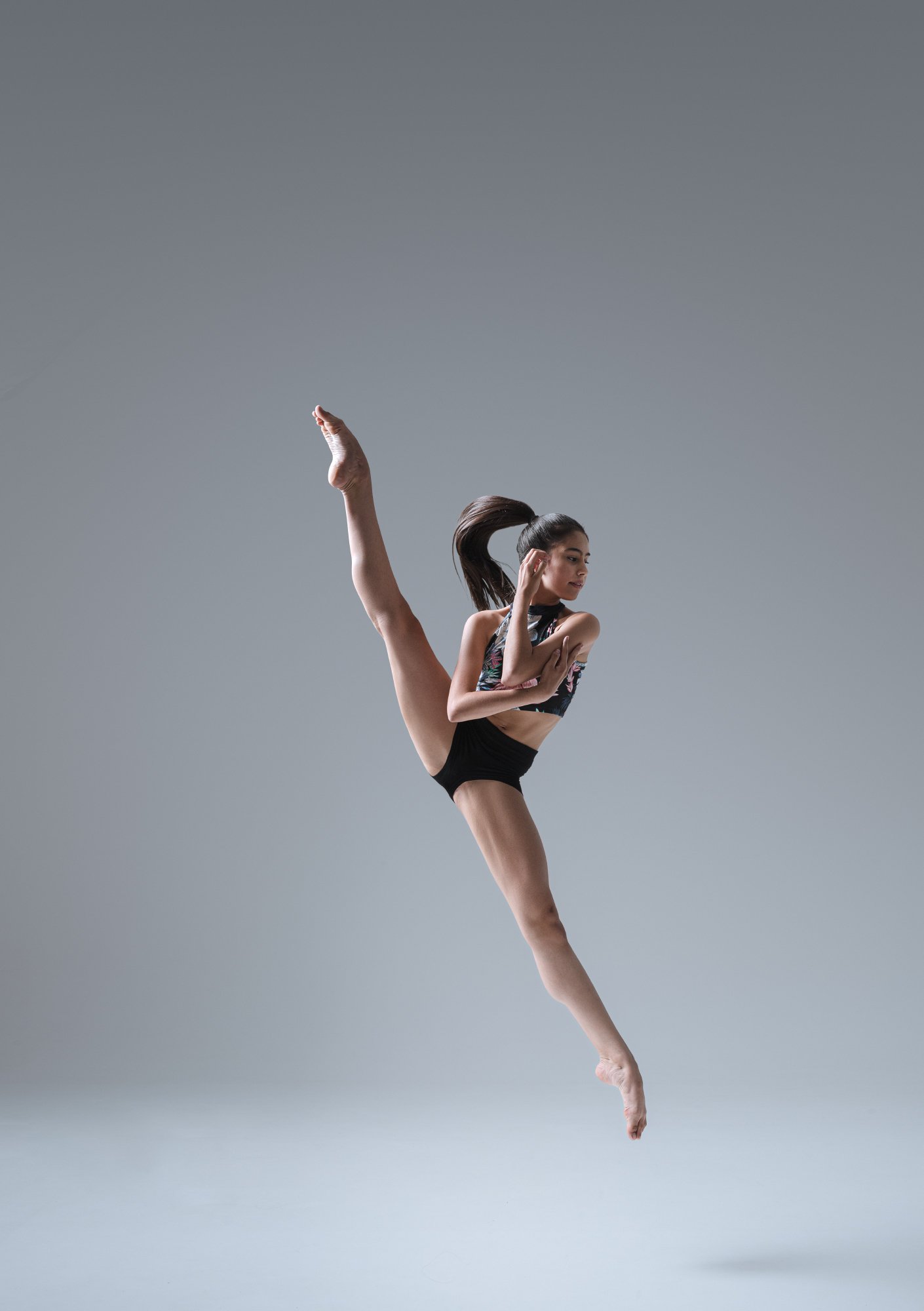 Ballet dancer demonstrating a high leg extension during a photoshoot.