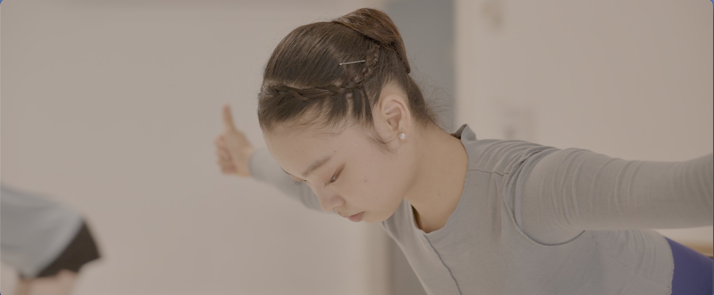 Dancer completing a strength and conditioning exercise with arms extended.