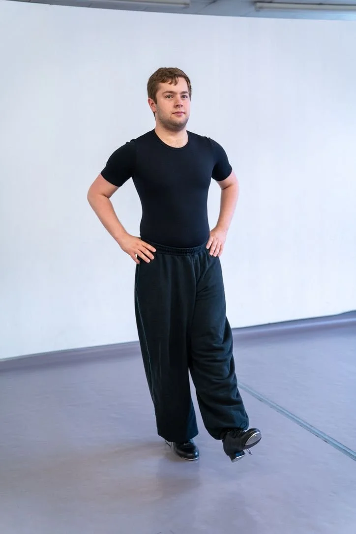 Adult tap student standing ready to practise in a dance studio.