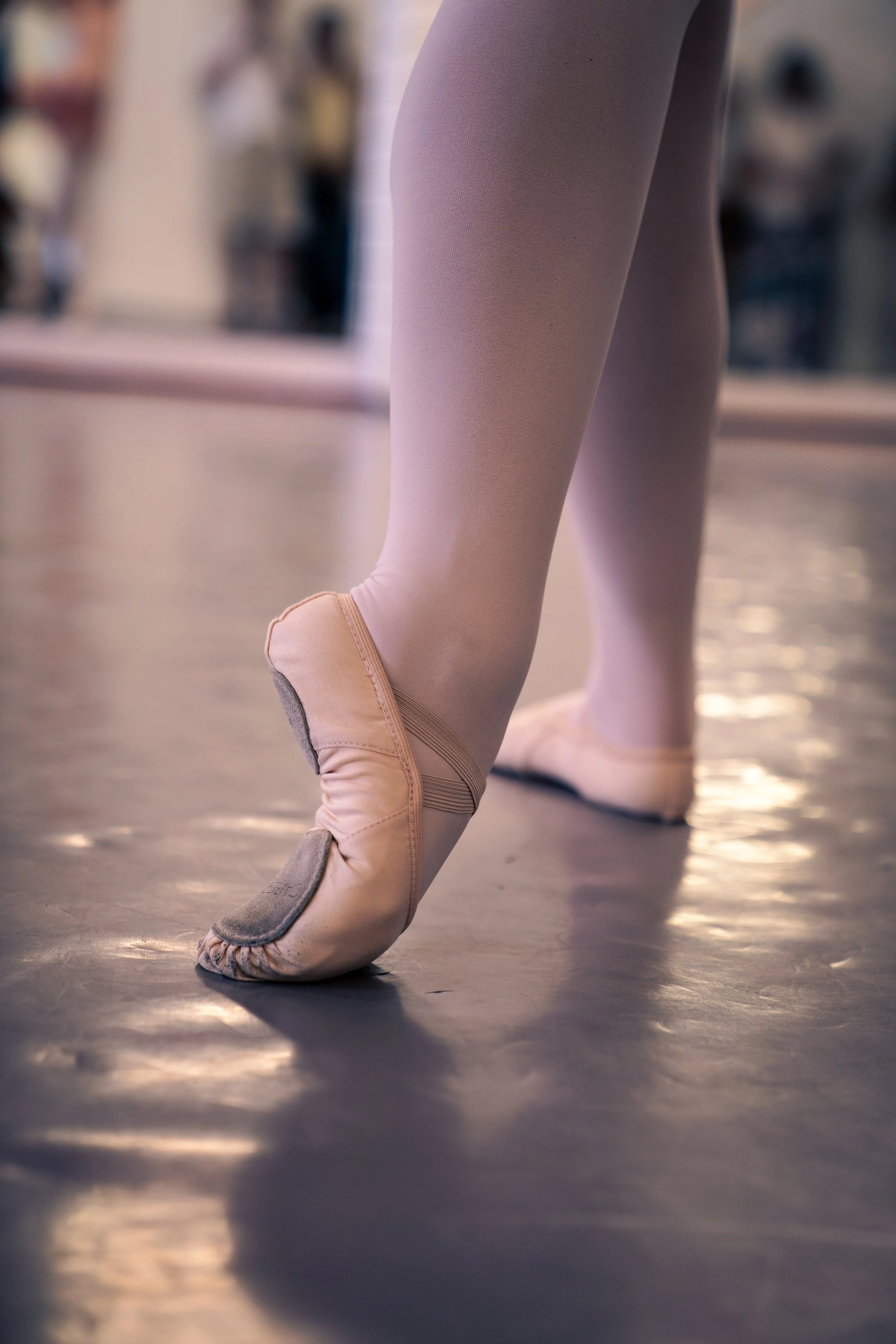 Close-up of a ballet dancer en pointe in pink tights and pointe shoes.