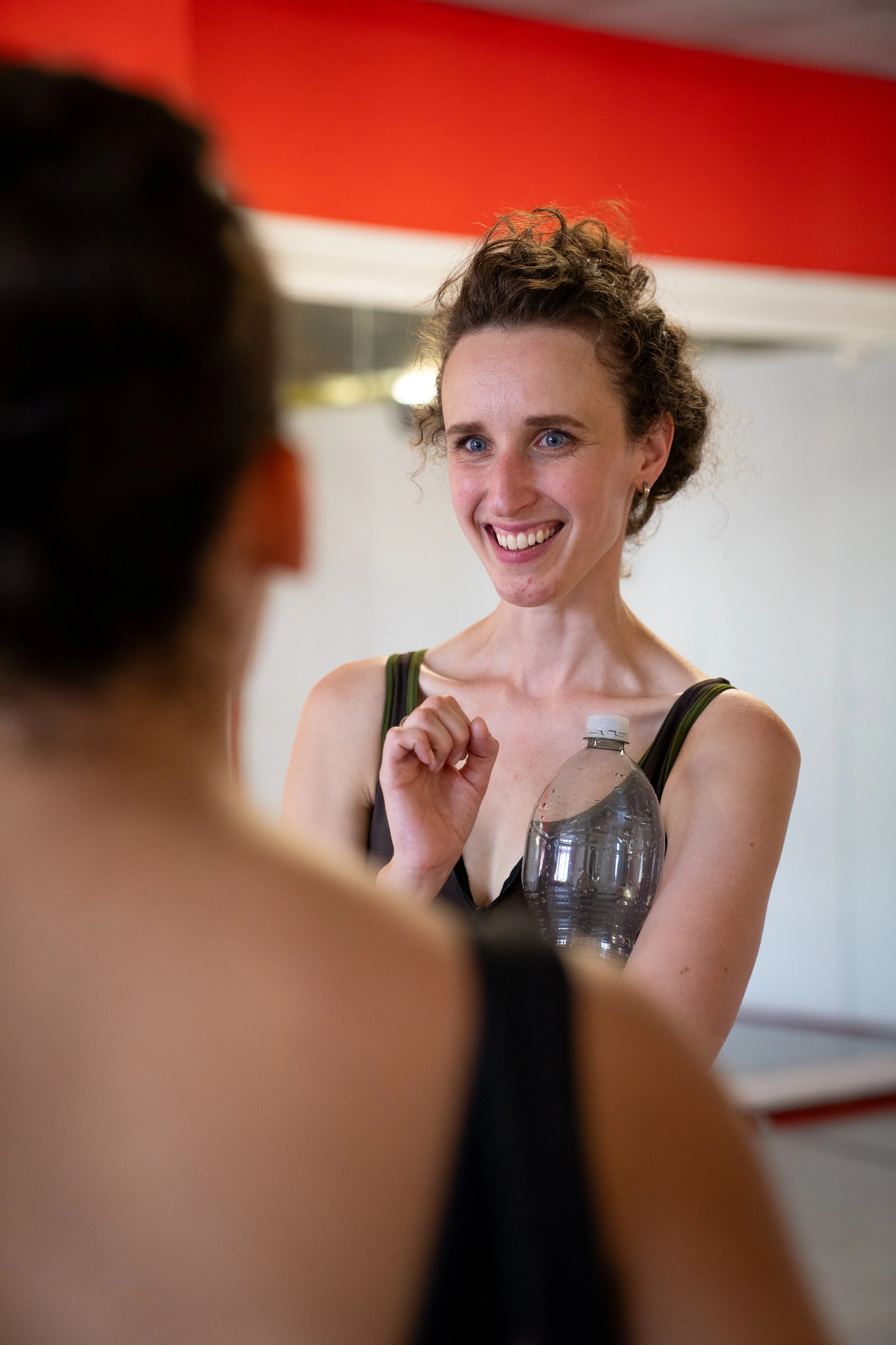 Ballet coach Emma Layne smiling and speaking with participant during a studio session.