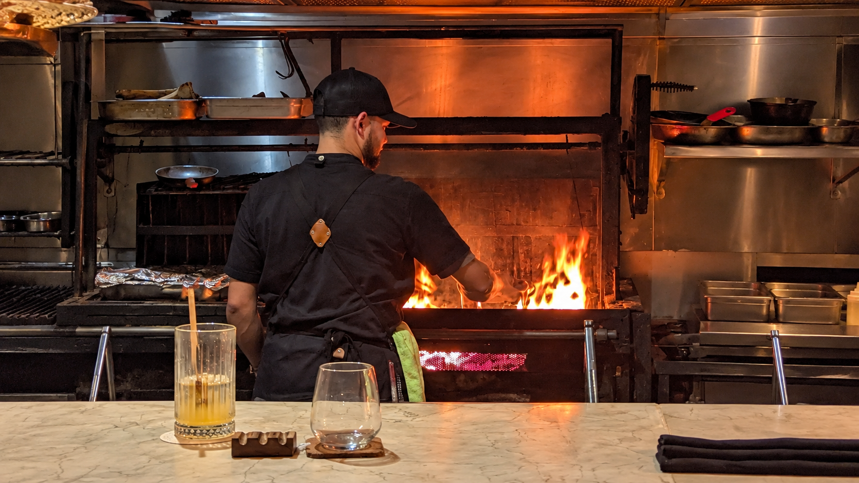 Chef cooking over the open fire in Kaandela’s open kitchen in Panama City, Panama.