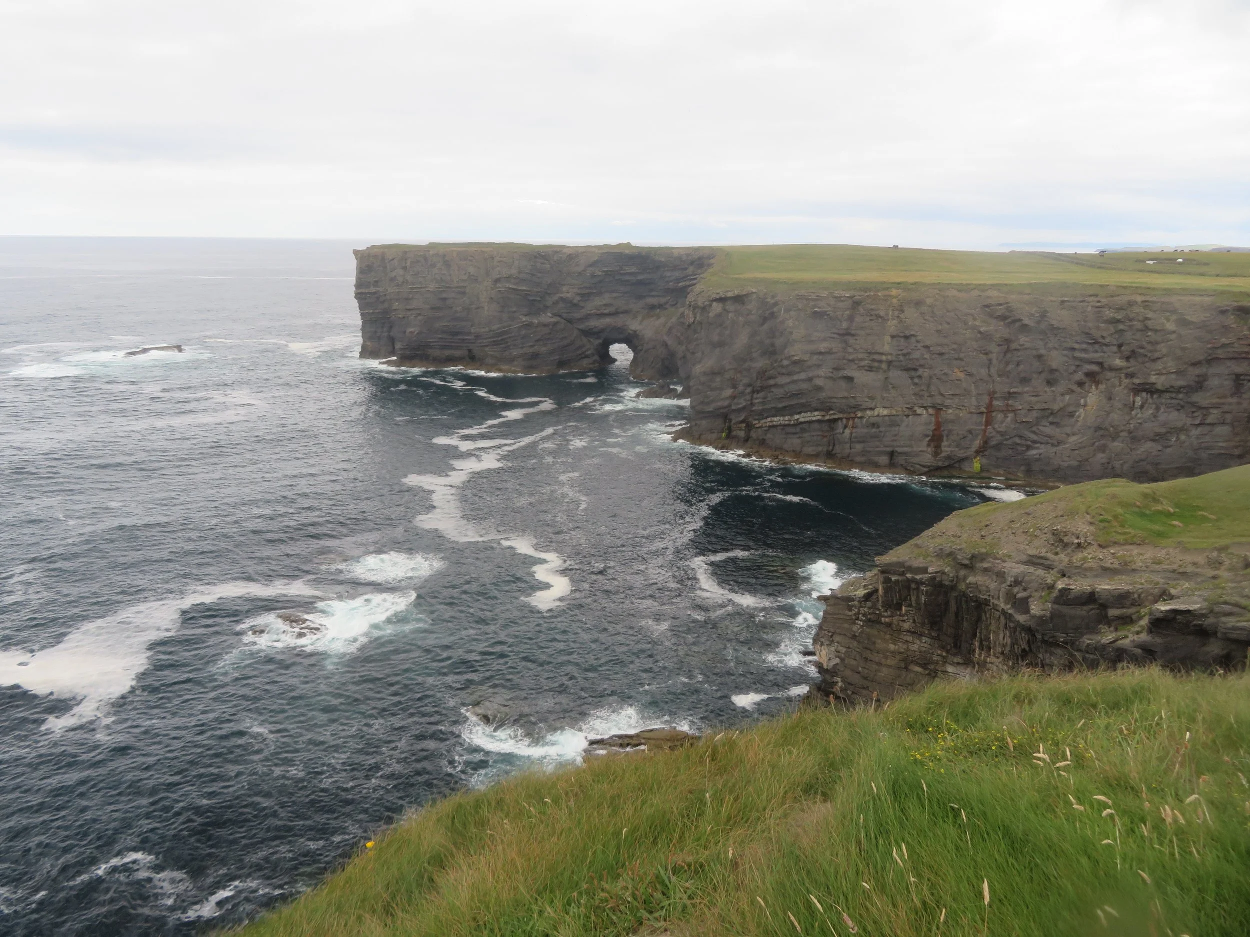 Rugged sea cliffs and the Atlantic Ocean along the Kilkee Cliffs on Ireland's County Clare coast.