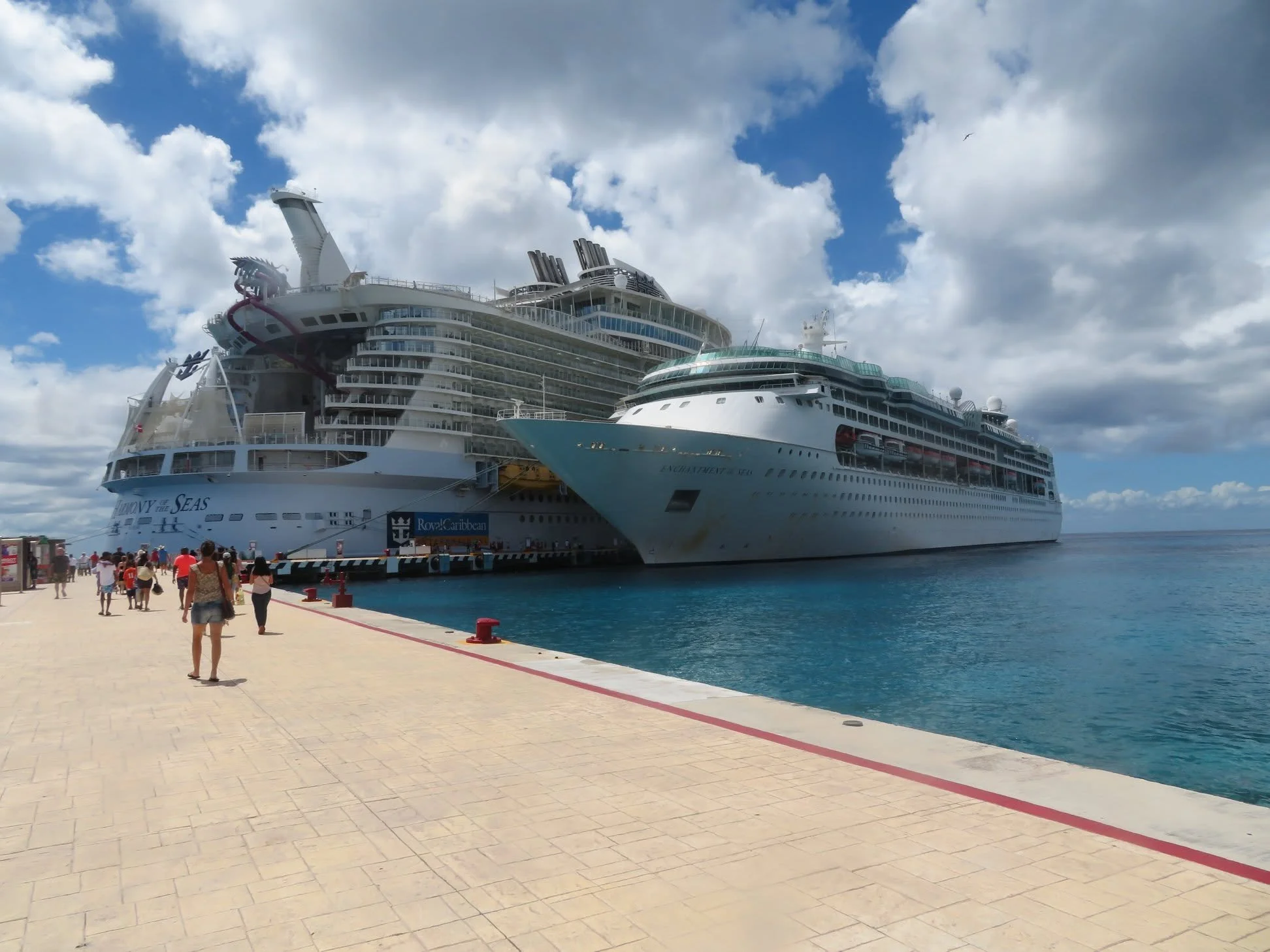 Two large cruise ships docked side by side beneath a bright blue sky