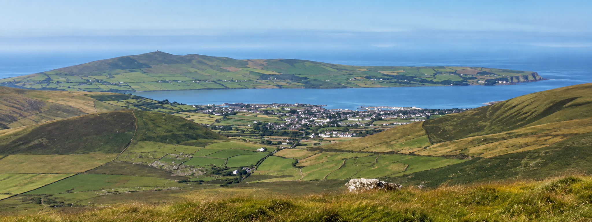 Panoramic view across the green hills toward Dingle and Dingle Harbour on Ireland's Dingle Peninsula