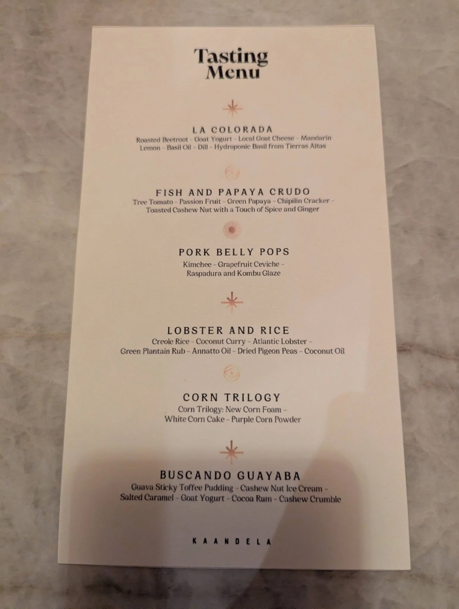 Printed chef's tasting menu at Kaandela restaurant featuring multiple Panamanian-inspired courses.